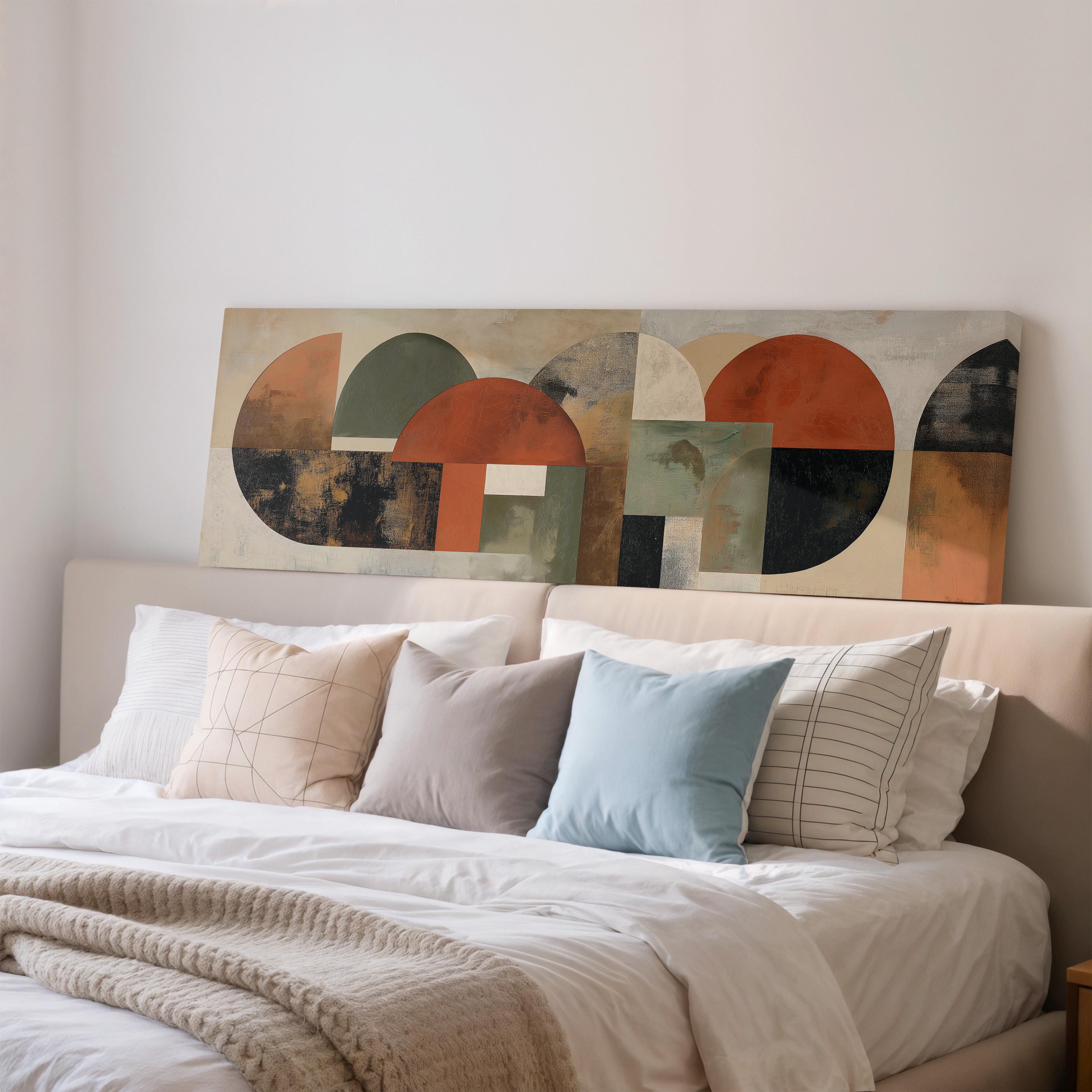 a large abstract painting hanging on a wall above a bed with white bedding and various pillows.