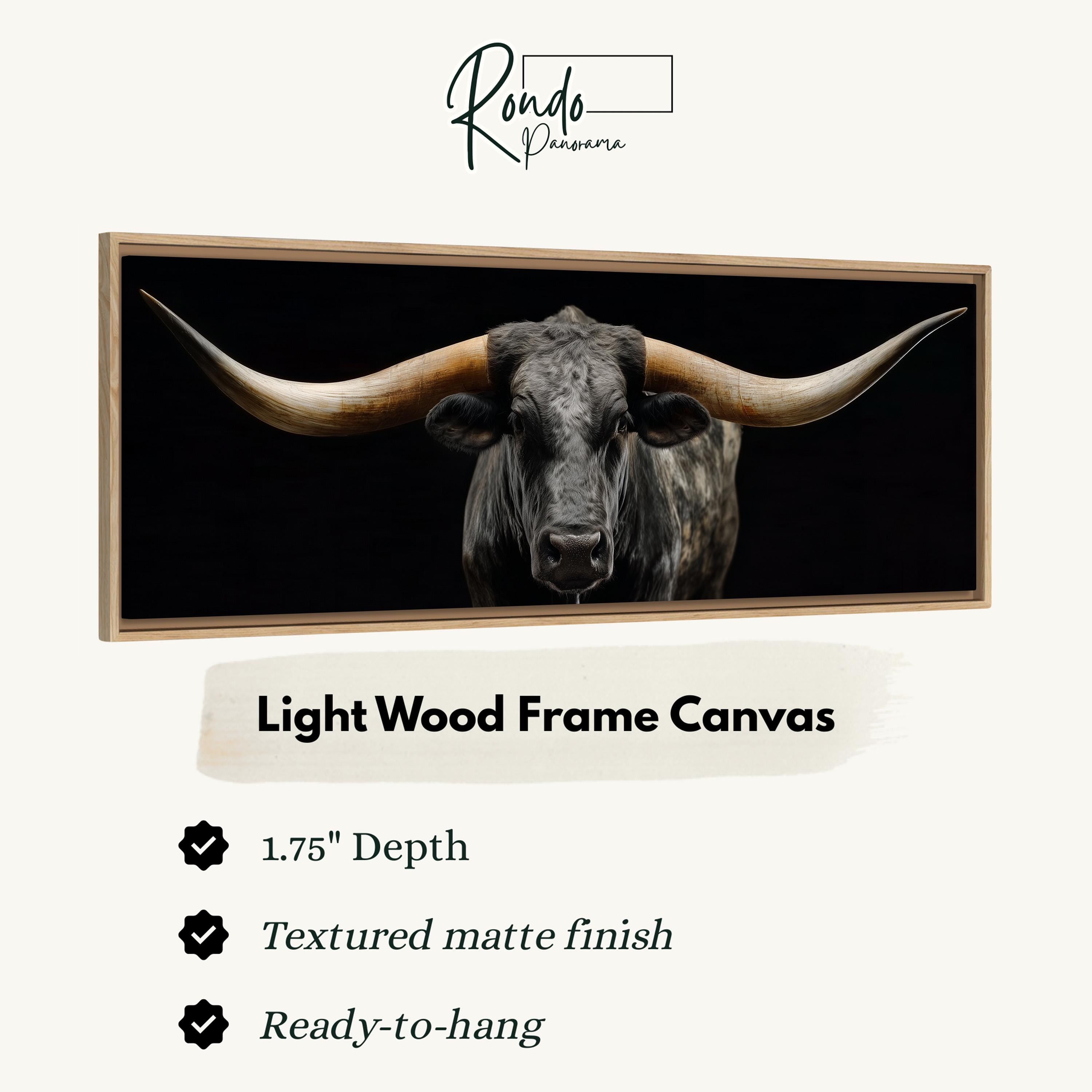 a close-up of a bull with large horns, displayed in a light wood frame canvas.