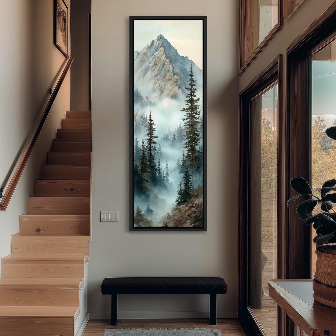 a large framed painting of a mountain landscape with pine trees and a misty, hazy atmosphere. The painting is hanging on a wall in a room with a wooden floor and a window.