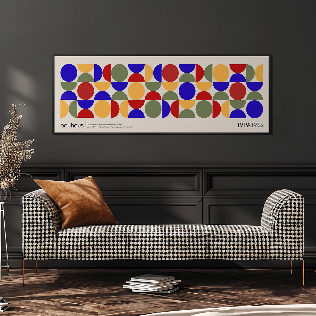 a modern living room with a checkered sofa, a stack of books, and a plant. Above the sofa, there is a framed abstract art piece with a geometric pattern of circles and rectangles in various colors.