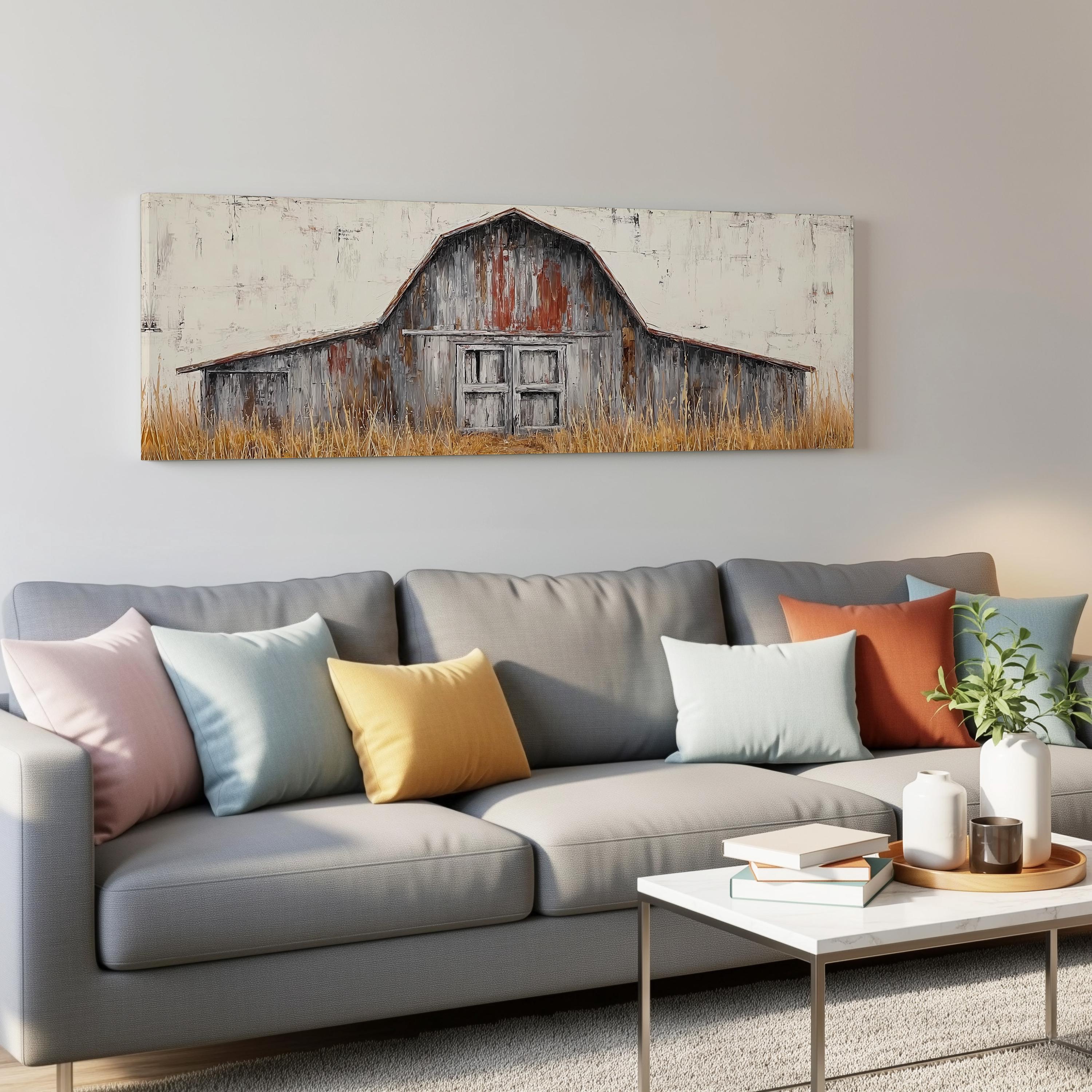 a living room with a gray couch adorned with colorful throw pillows, a coffee table, and a large painting of a rustic barn above the couch.