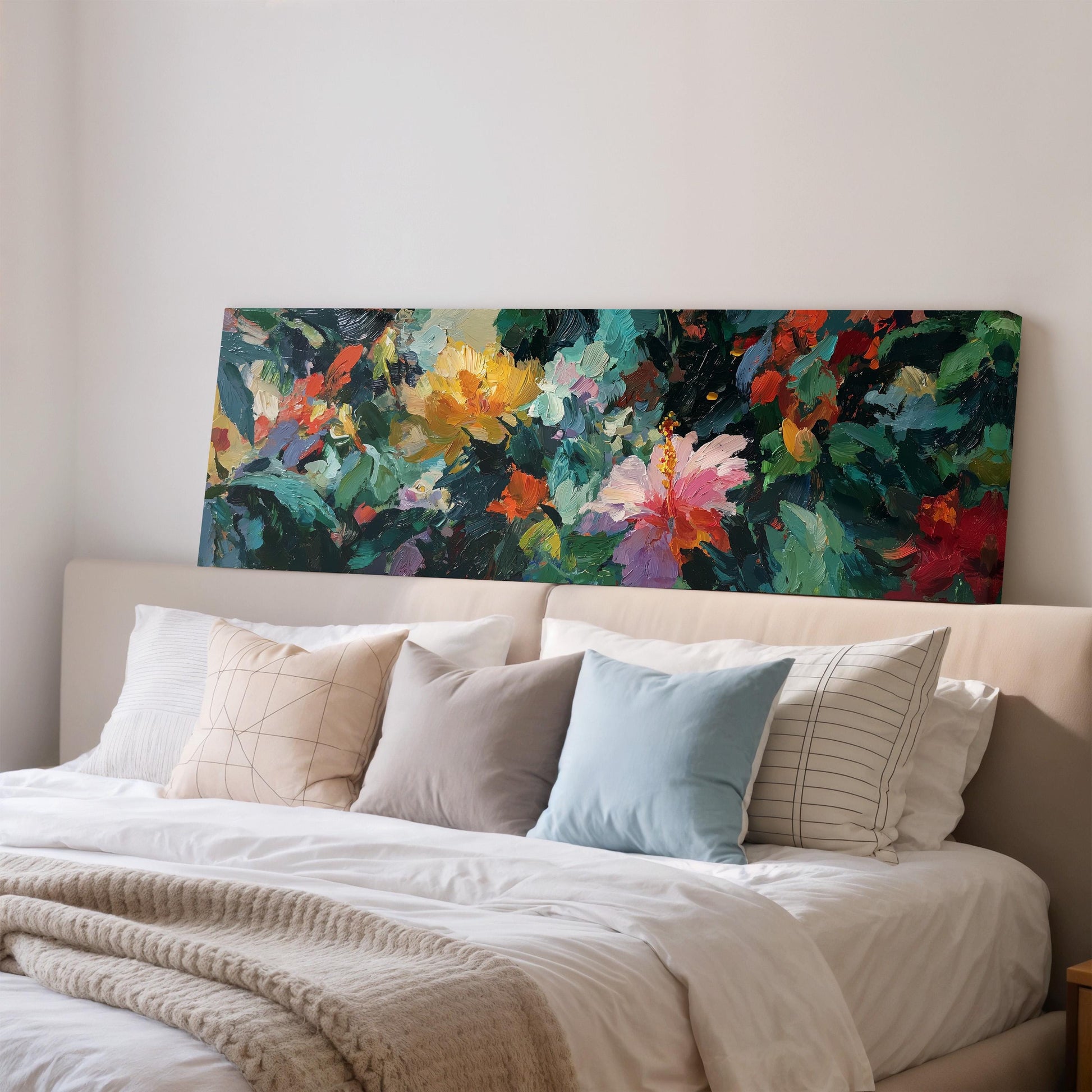 a large, colorful painting of flowers hanging above a bed with white pillows and a beige comforter.