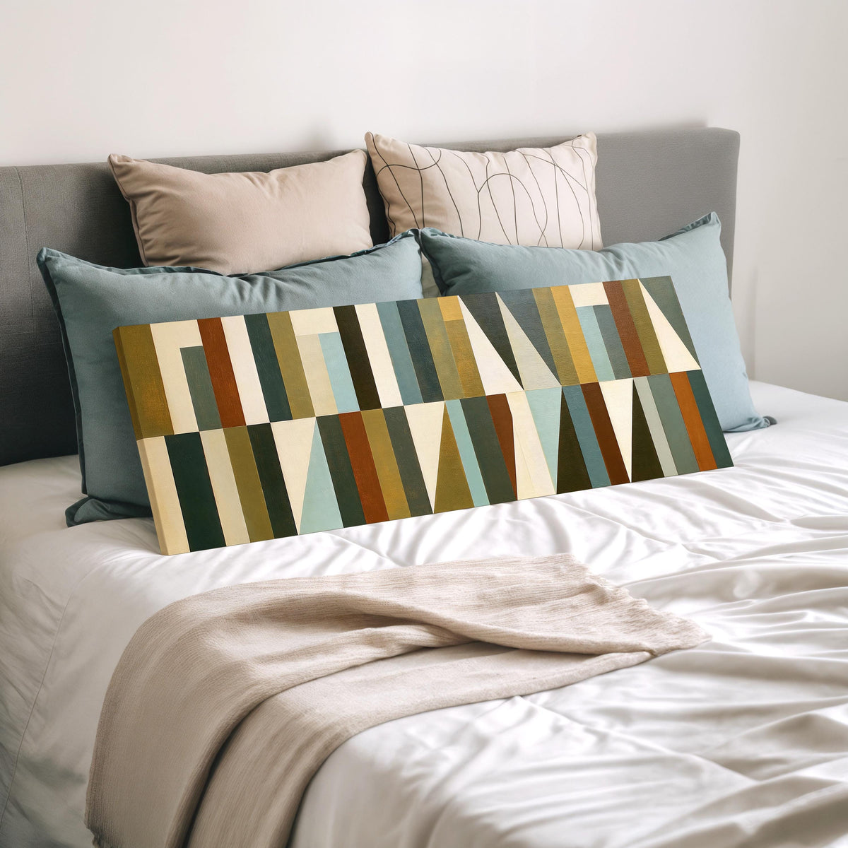 Earth tone geometric triangles wide panoramic canvas print laid on a bed to show its size