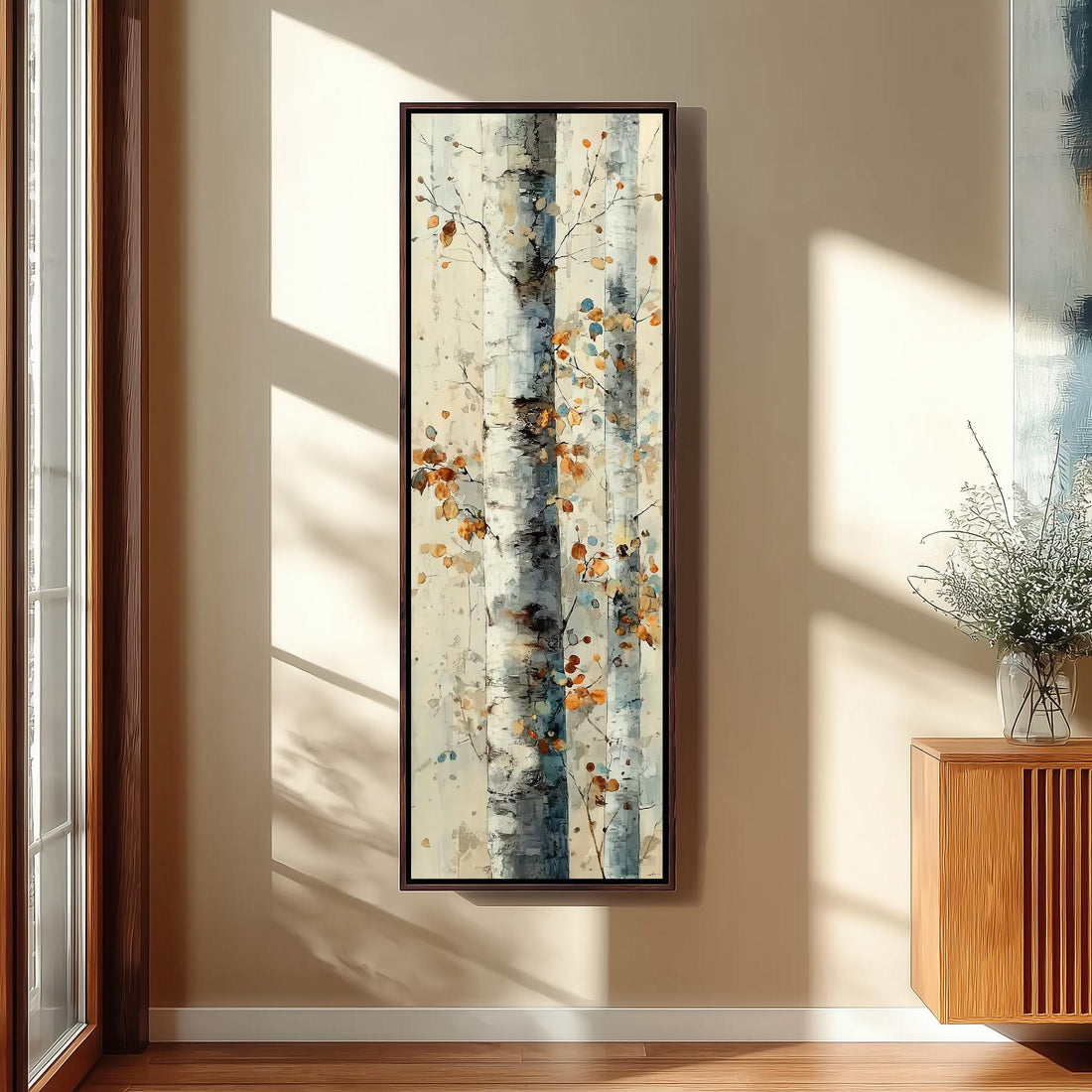 a large, abstract painting of a tree with a mix of blue, white, and orange colors, hanging on a white wall in a room with a wooden chair and a small table.