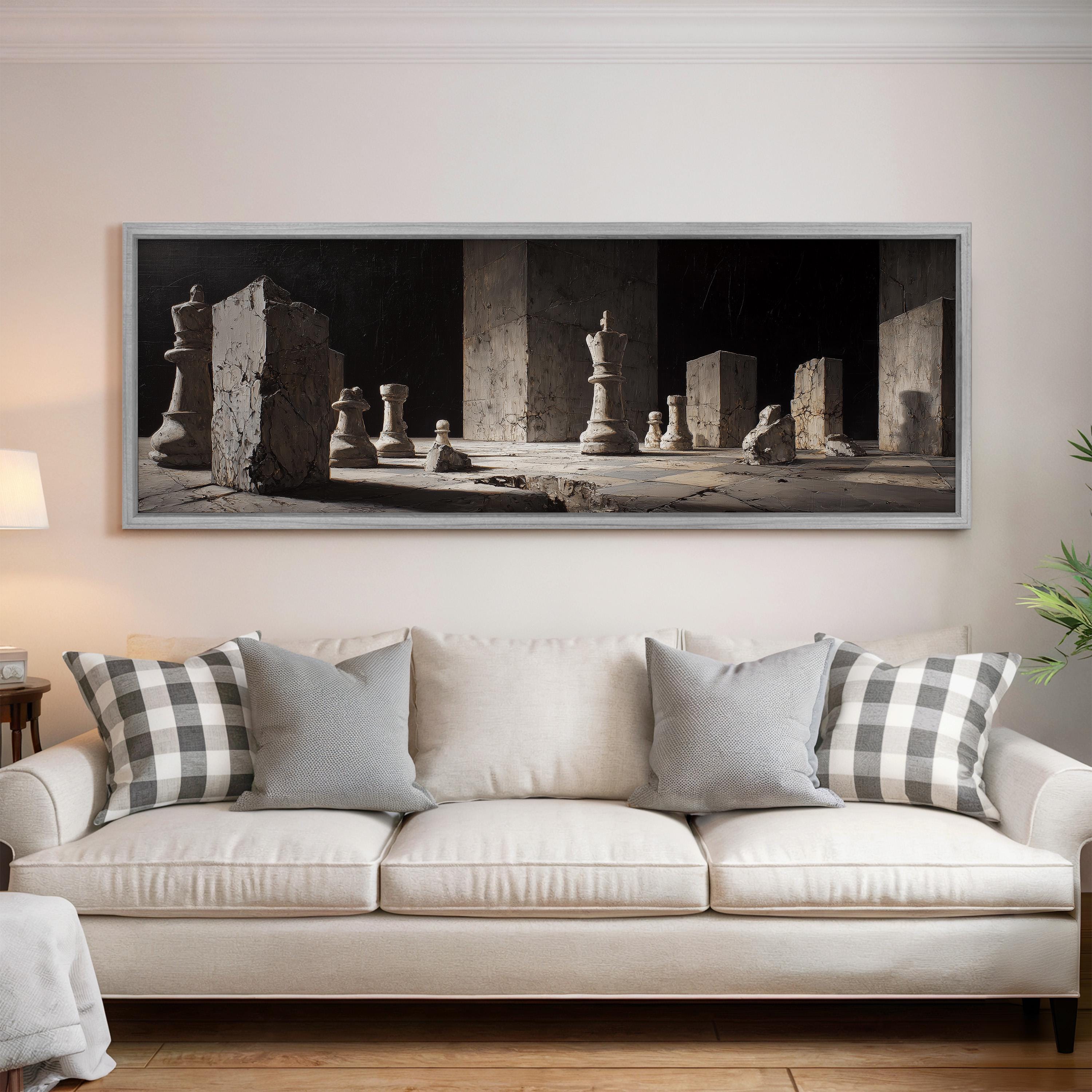 a large black and white photograph of chess pieces arranged on a chessboard, hanging on a wall above a white sofa with patterned throw pillows.