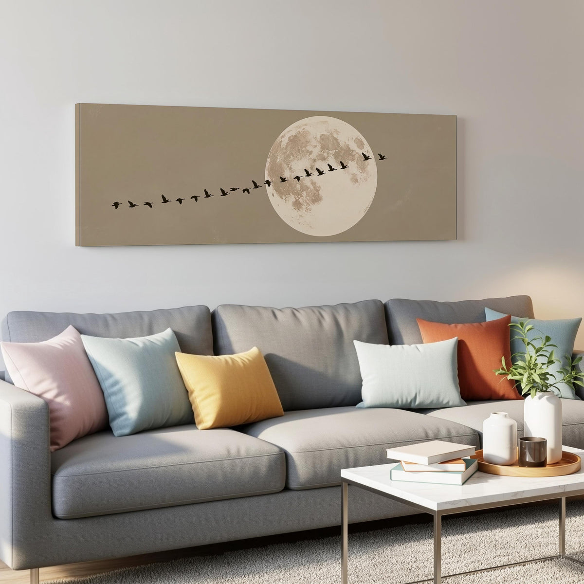 Geese flying past a full moon panoramic canvas print above a grey sofa in a living room