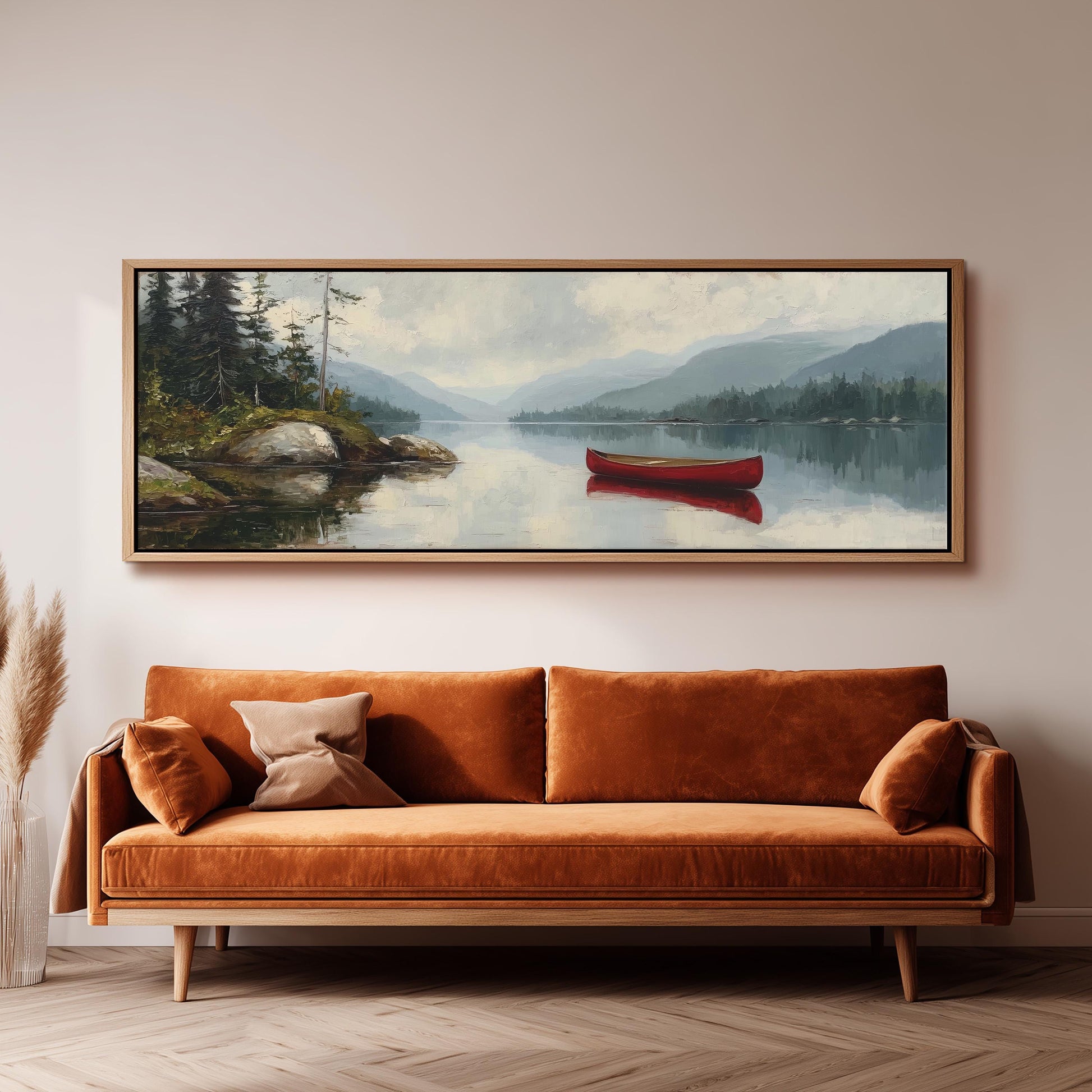 a large painting of a red canoe on a lake, hanging on a wall above a brown sofa.