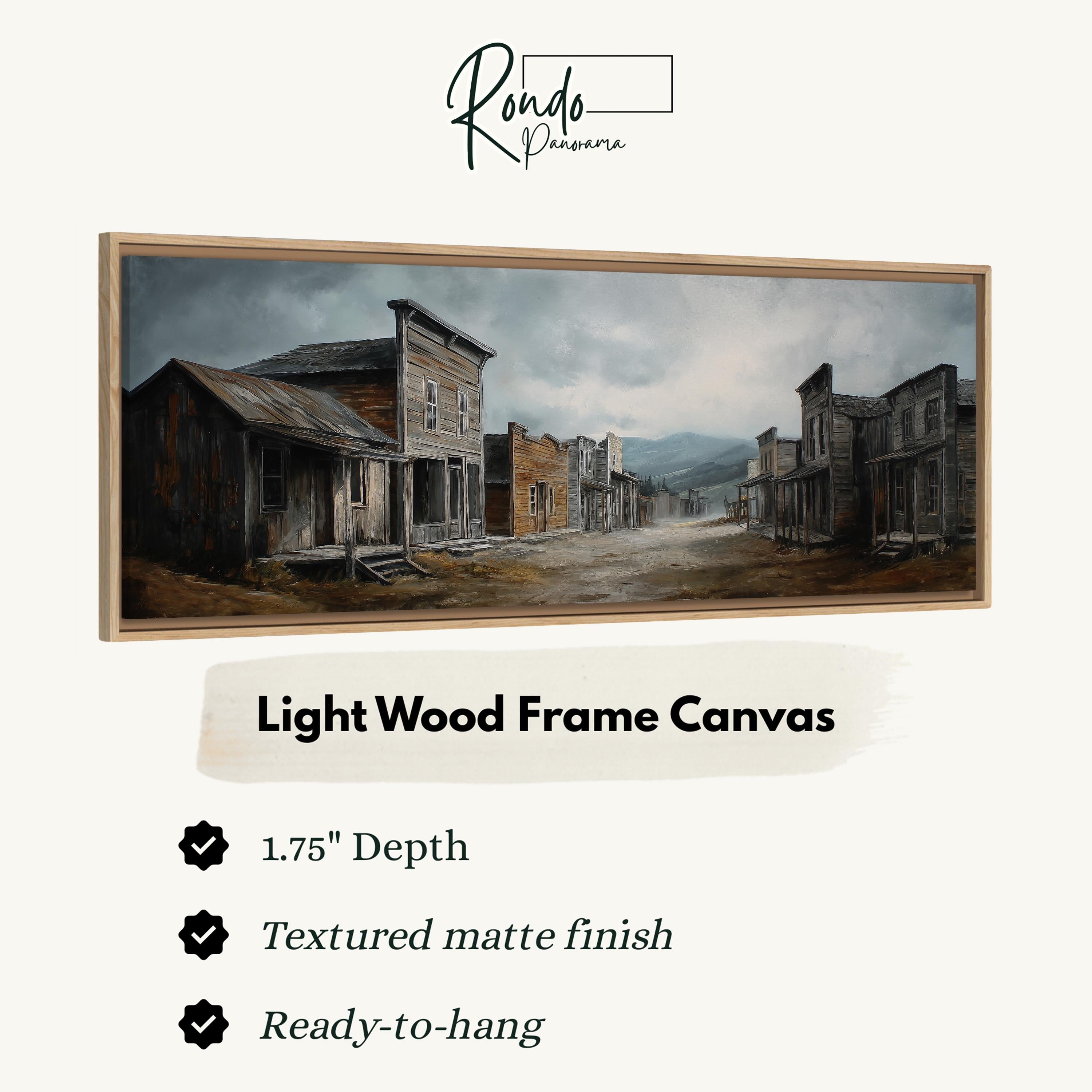 The image is a painting of a small town street with old buildings, and it is framed as a light wood frame canvas.