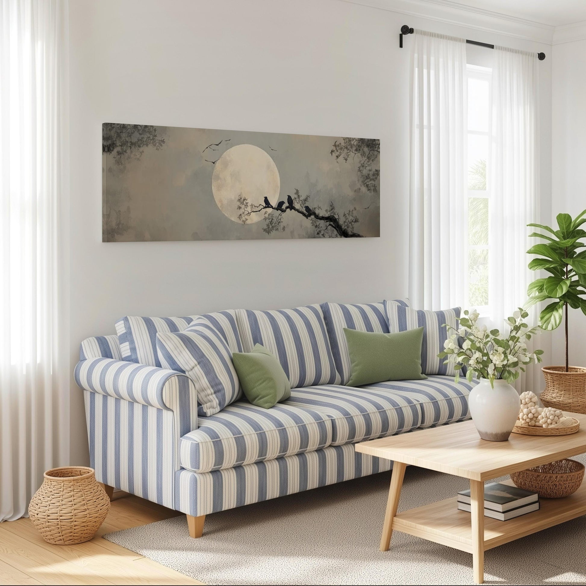 a cozy living room with a striped blue and white sofa, a wooden coffee table, and a large window with white curtains. Above the sofa, there is a large painting of a moonlit night scene with silhouetted trees and a full moon.