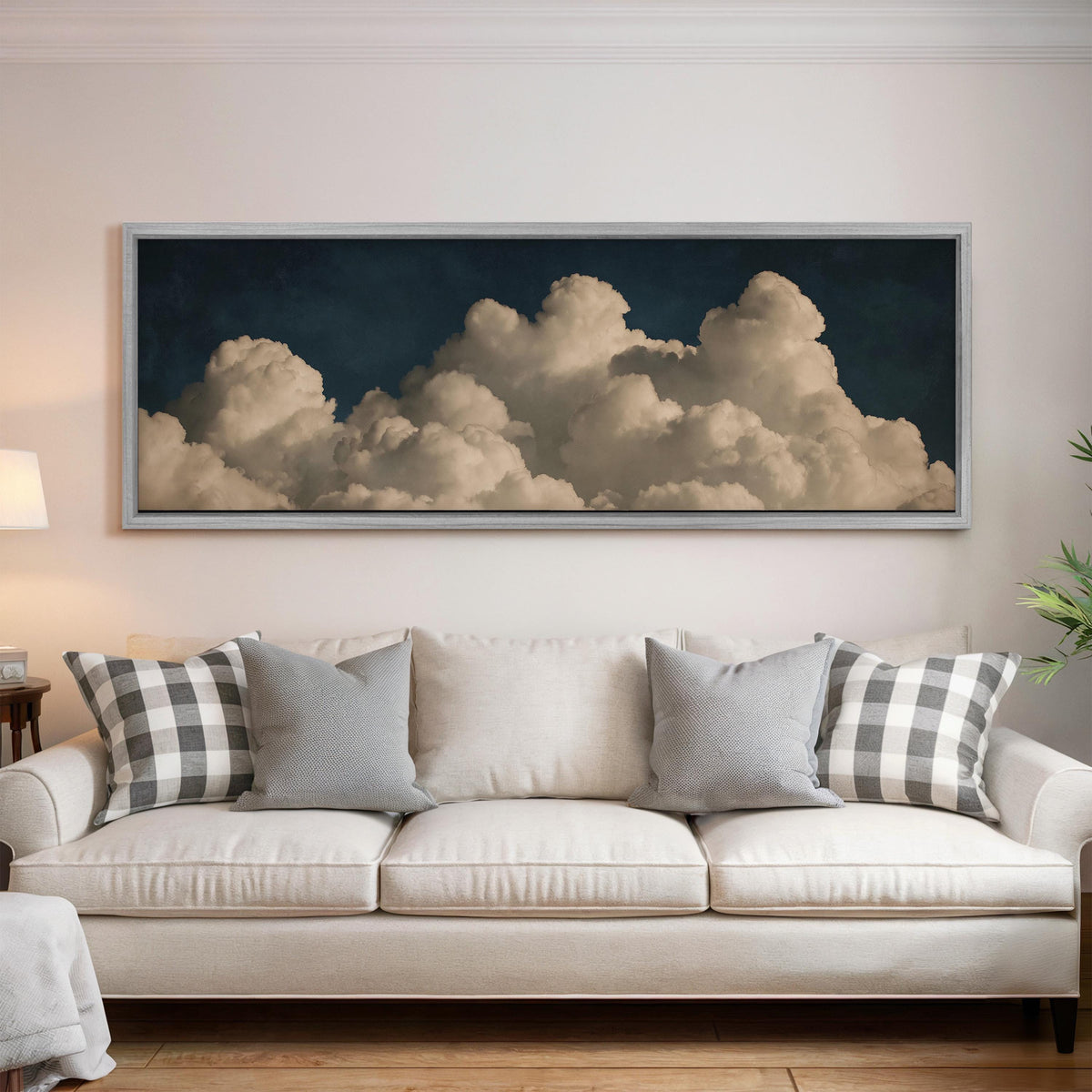 Cumulus clouds against a dark night sky panoramic canvas print above a white sofa in a bright living room