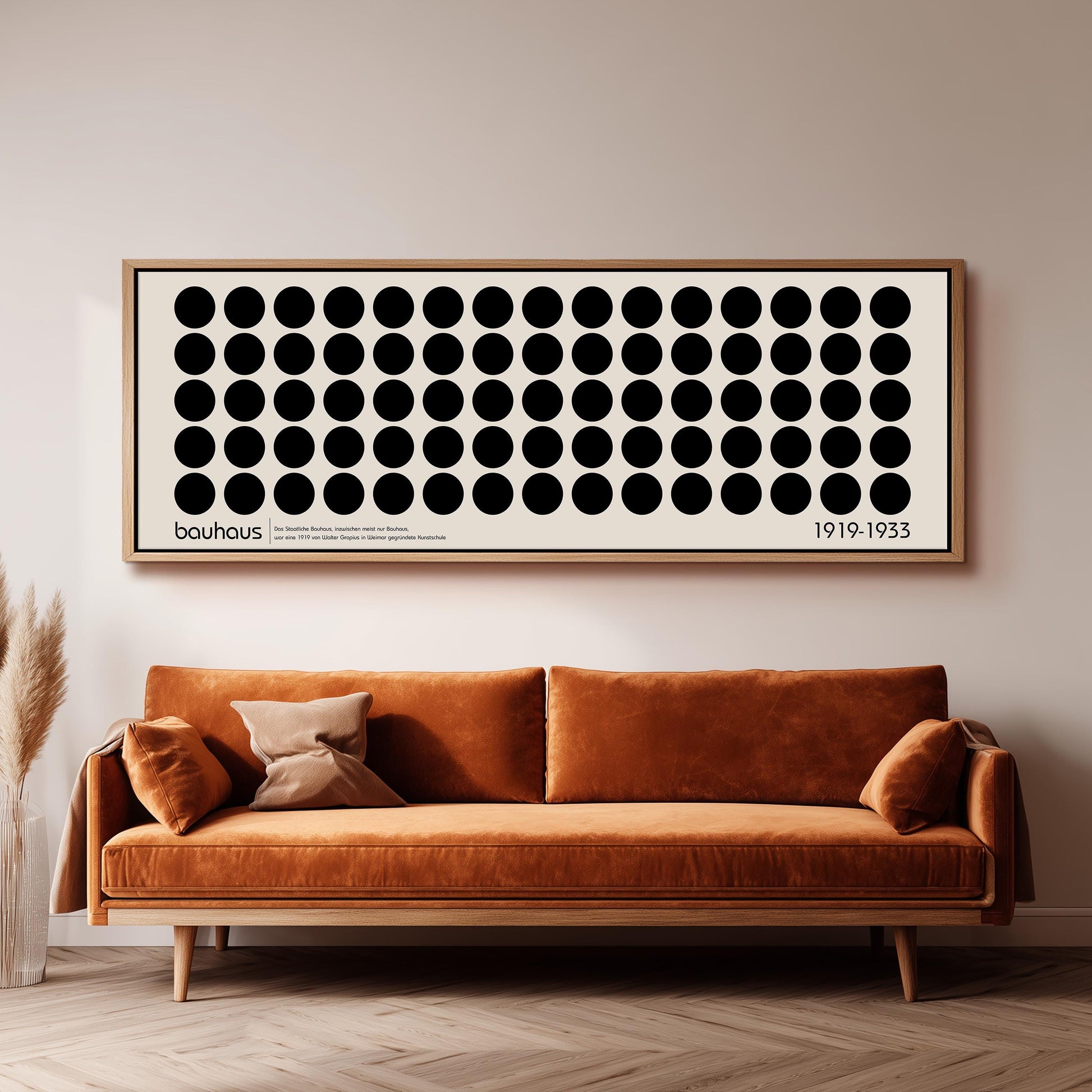 a large black and white abstract artwork hanging on a wall above a brown sofa.