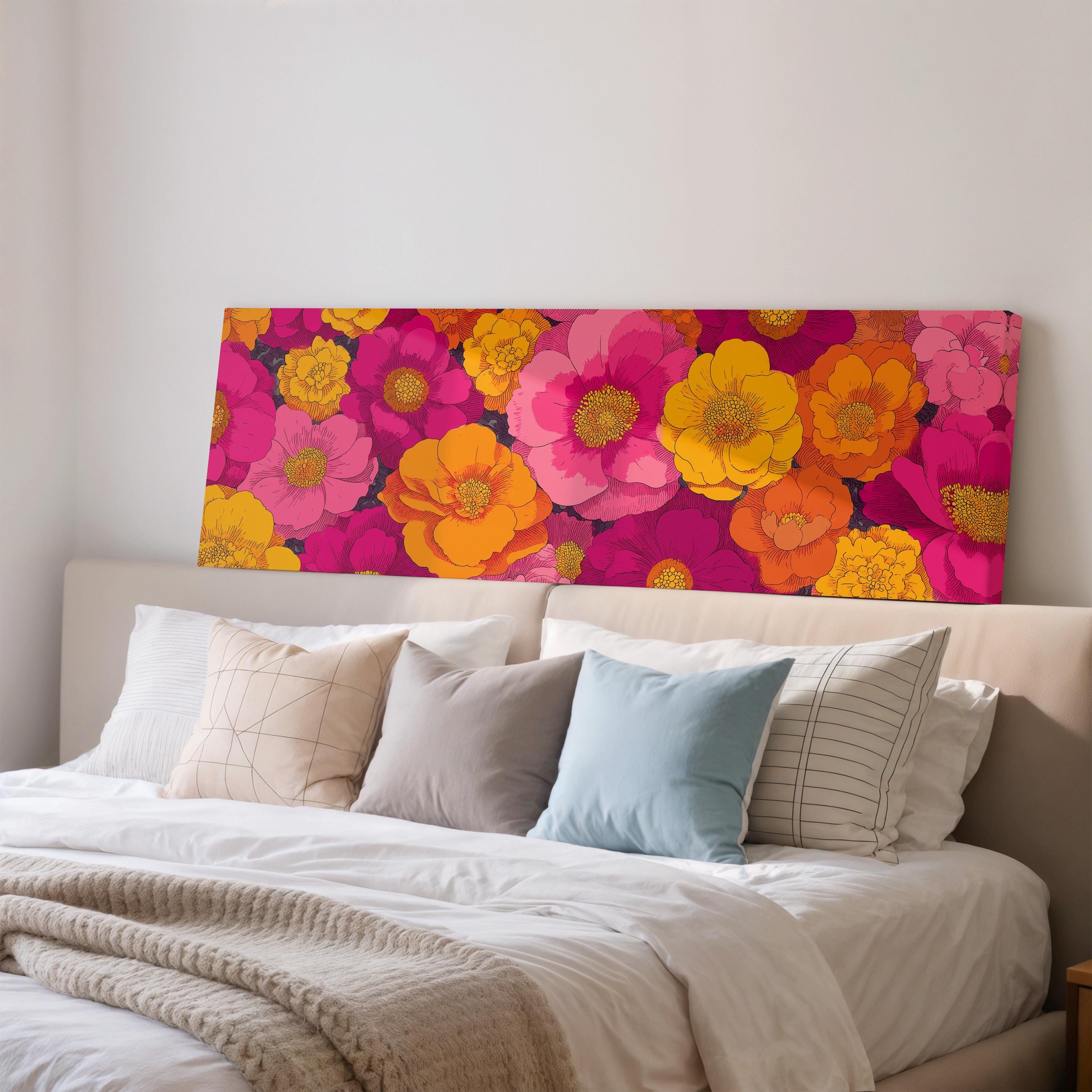 a large, colorful floral print displayed on a wall above a bed with white bedding and pillows.
