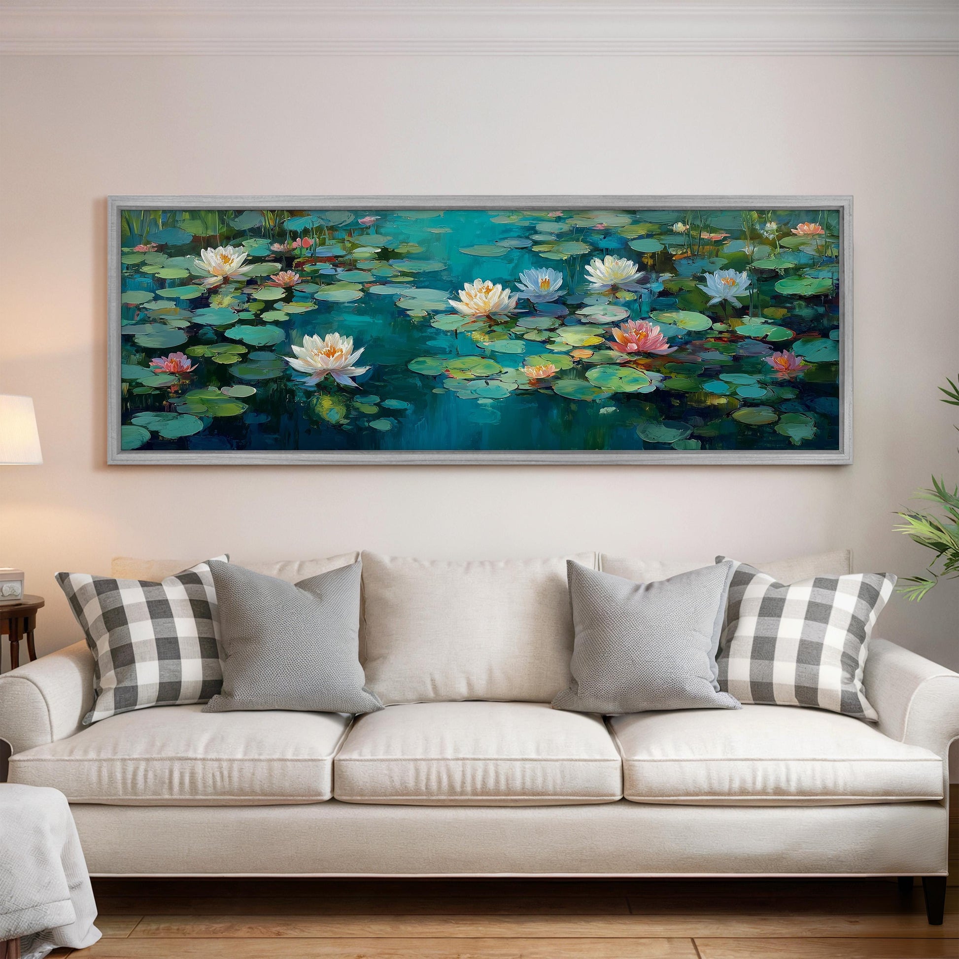 a large painting of lily pads hanging on a wall above a white couch with gray and white pillows.