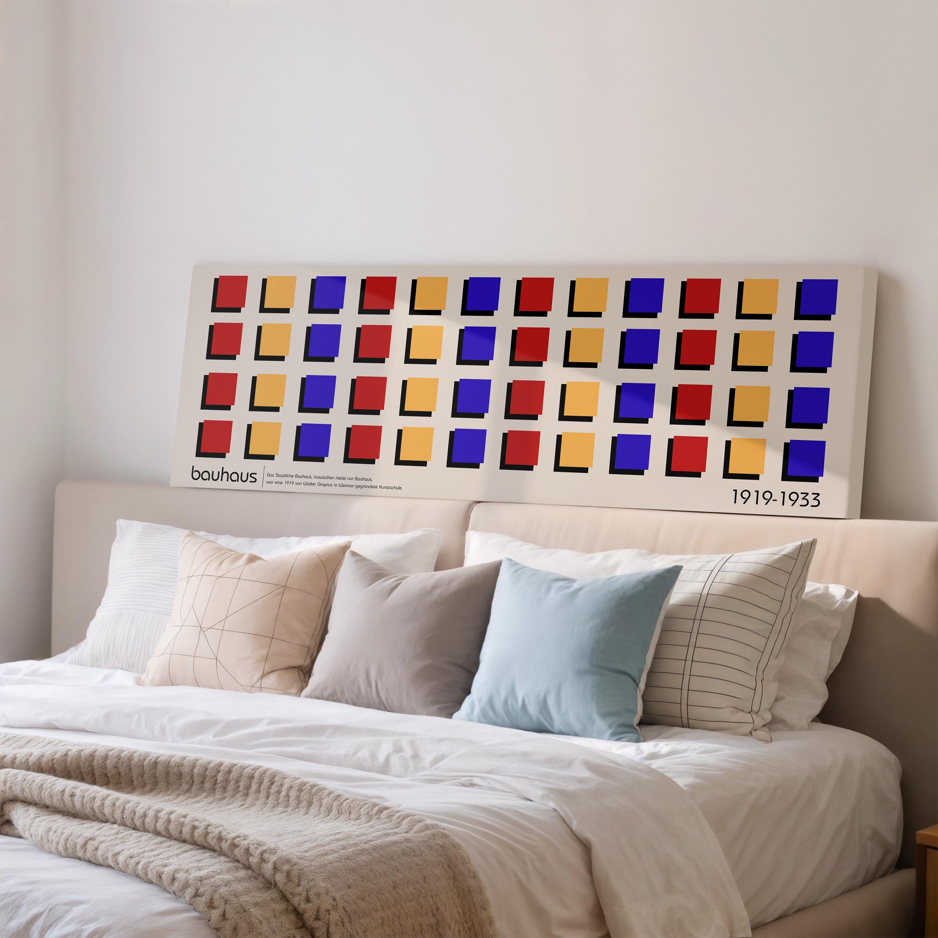 a large, colorful abstract art piece displayed on a wall above a bed with white bedding and pillows.
