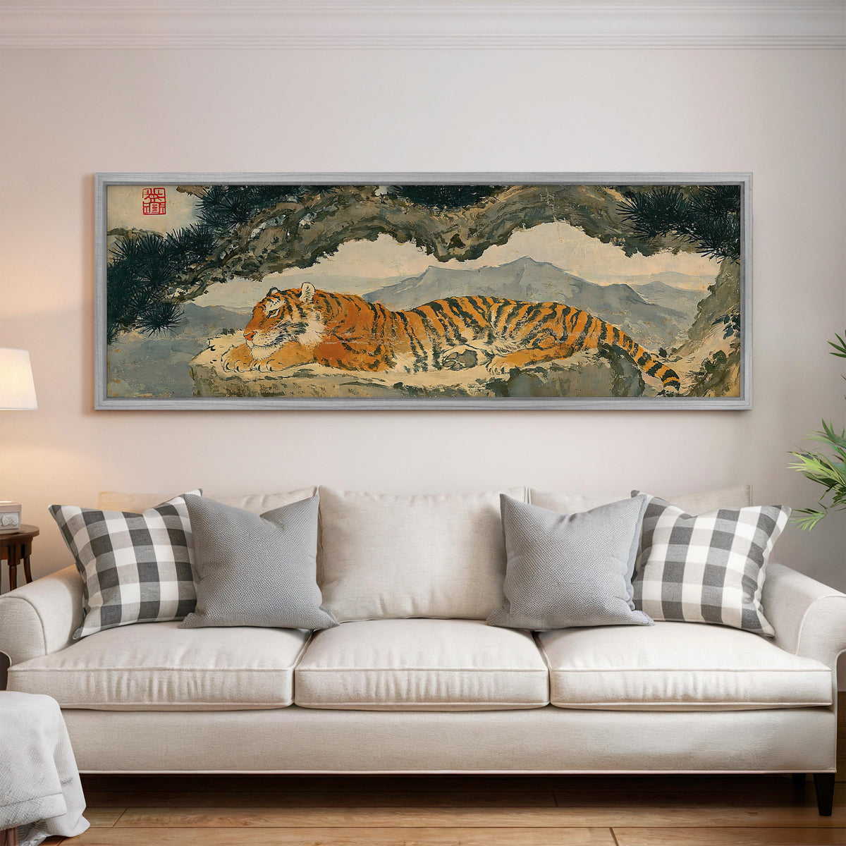 Tiger resting beneath misty pines panoramic canvas print above a white sofa in a bright living room