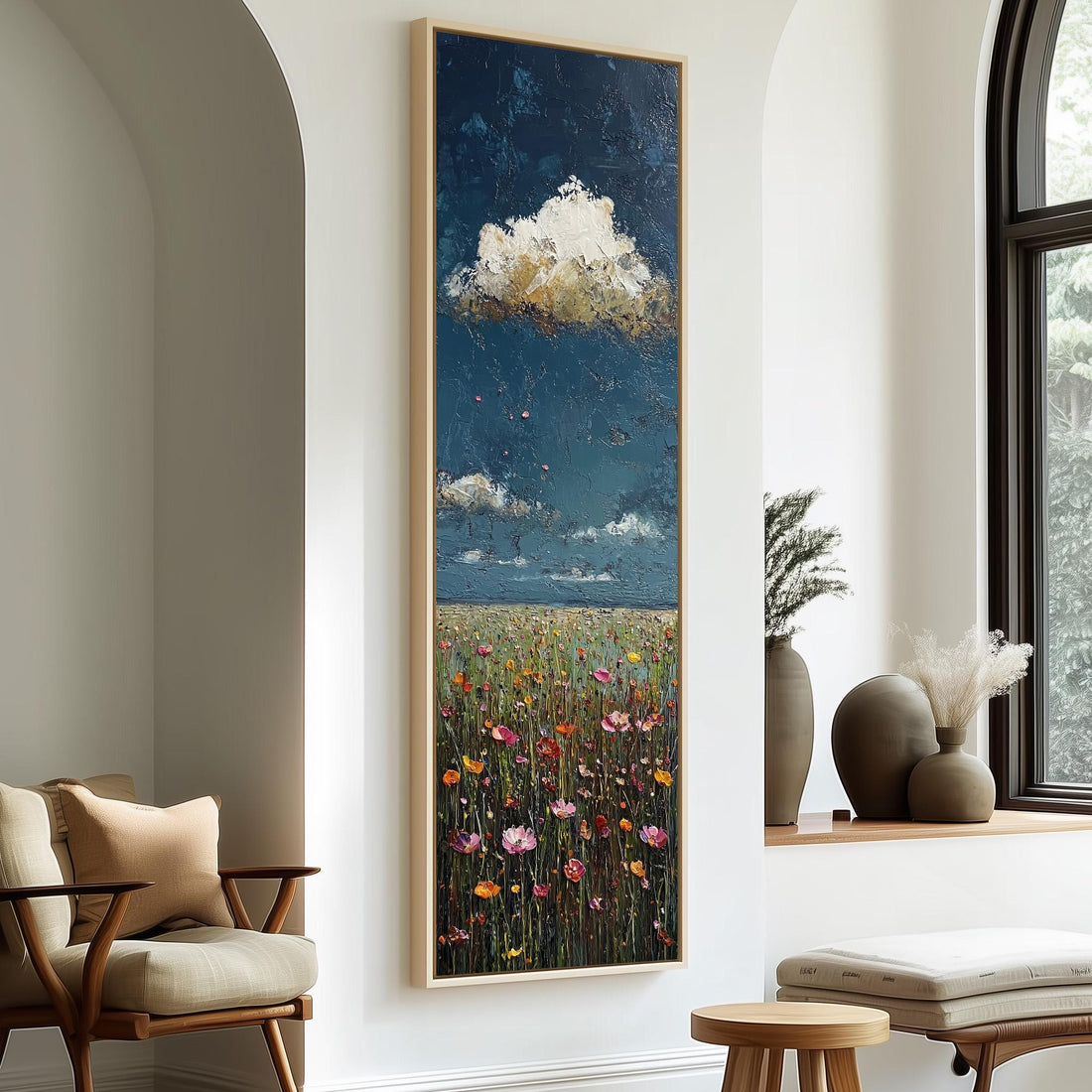 a large painting of a field with flowers hanging on a wall, accompanied by a wooden chair and a small table in a room with a window.