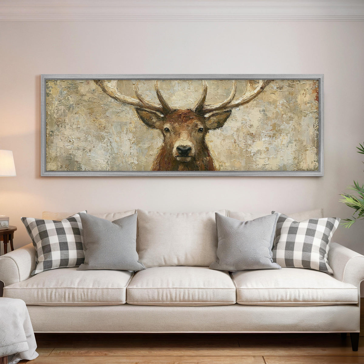 Rustic stag portrait panoramic canvas print above a white sofa in a bright living room