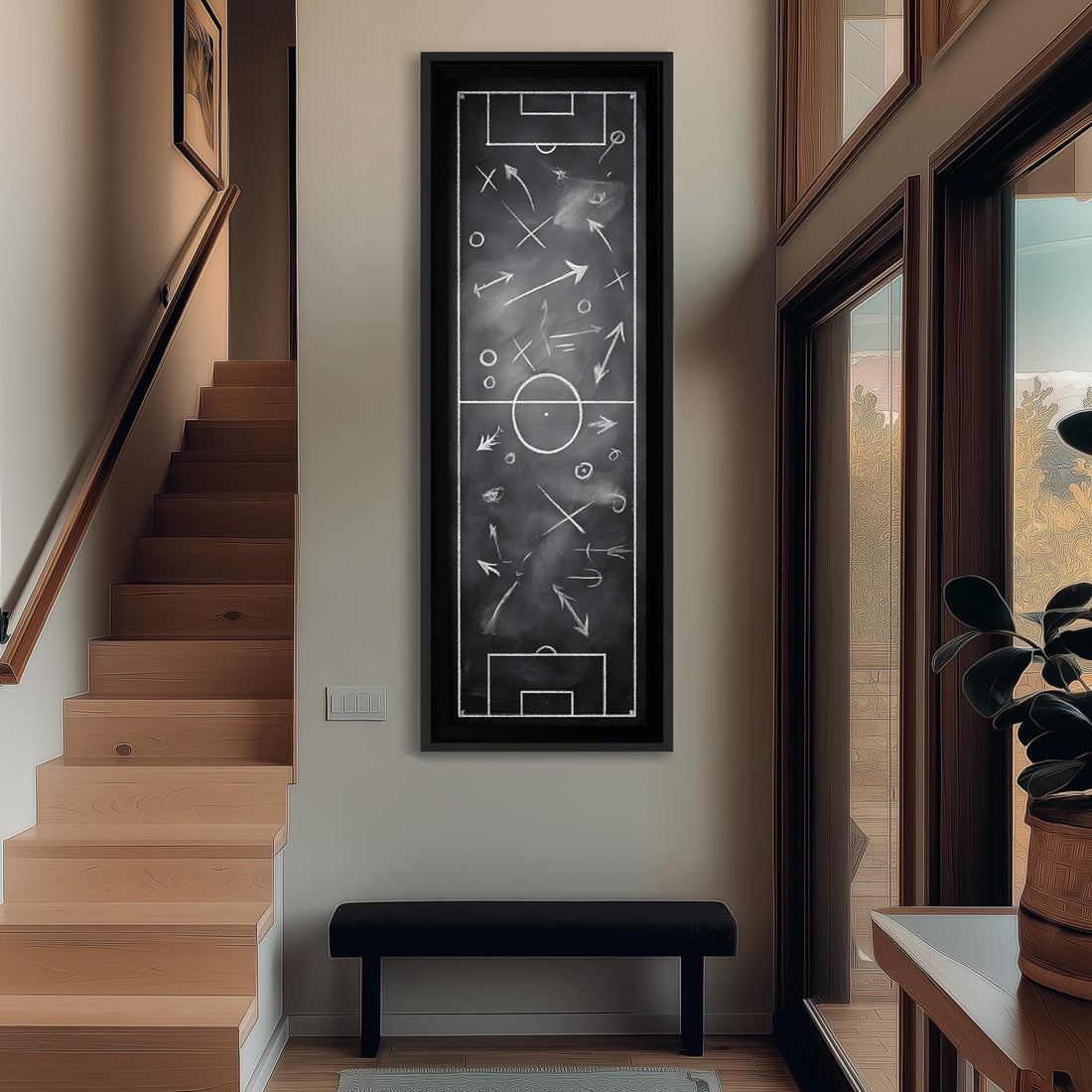 a hallway with a large black and white chalkboard-style artwork hanging on the wall, depicting a soccer field with various elements such as a goal, ball, and players. The hallway also includes a staircase, a bench, and a potted plant, creating a cozy and inviting atmosphere.