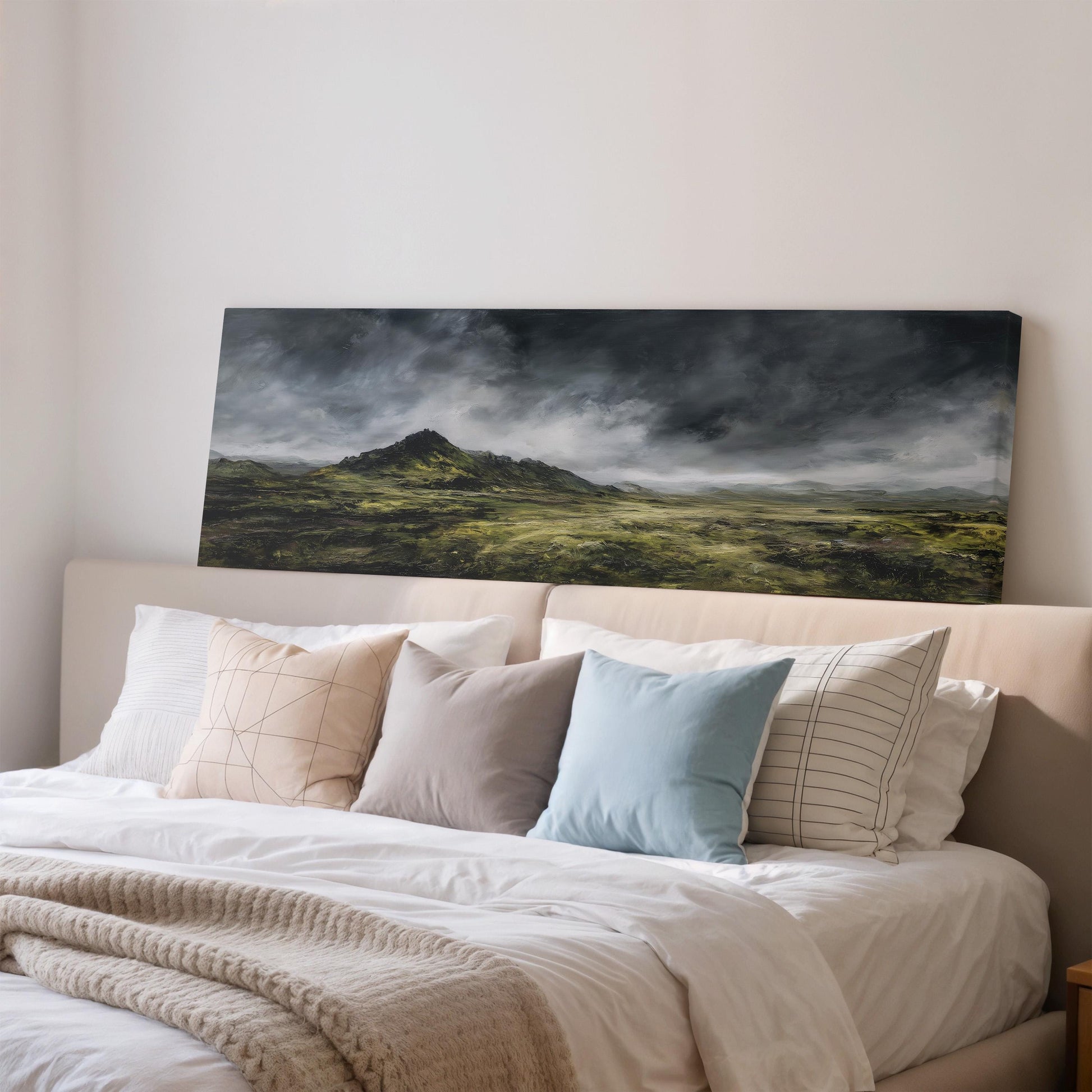 a large landscape painting hanging on a wall above a bed with white bedding and pillows.