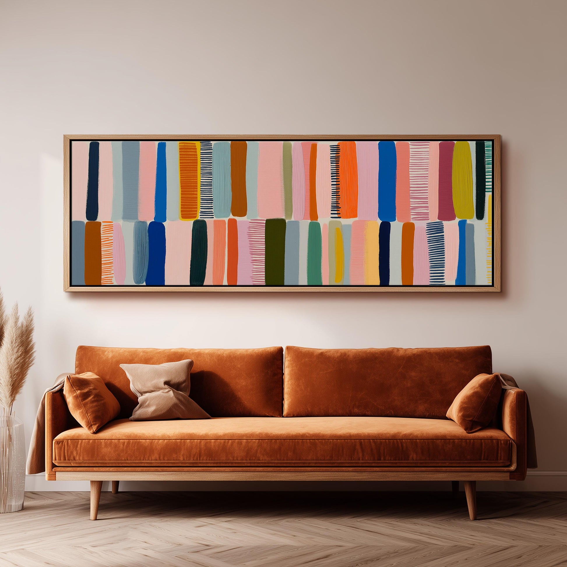 a large, colorful abstract painting hanging on a wall above a brown sofa.