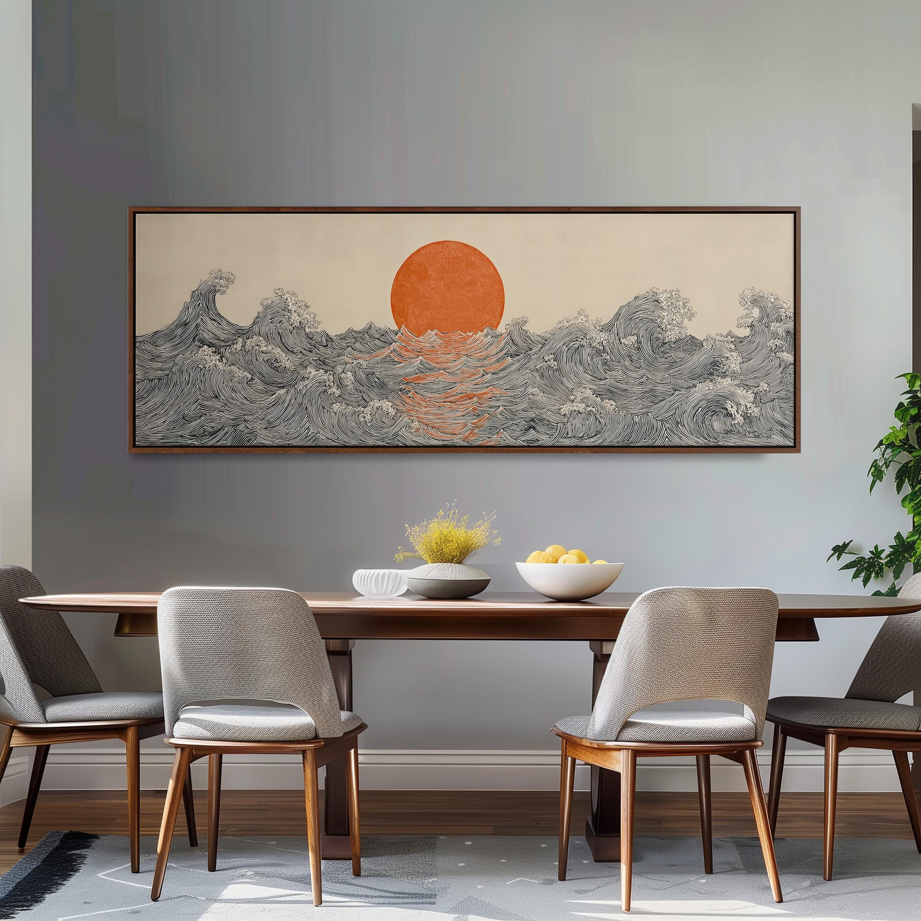 a dining room with a large, framed artwork depicting a sunset over a wave-covered ocean. The artwork is hung on the wall above a wooden dining table with four chairs. The table is set with a bowl of fruit and a vase of flowers, creating a cozy and inviting atmosphere.