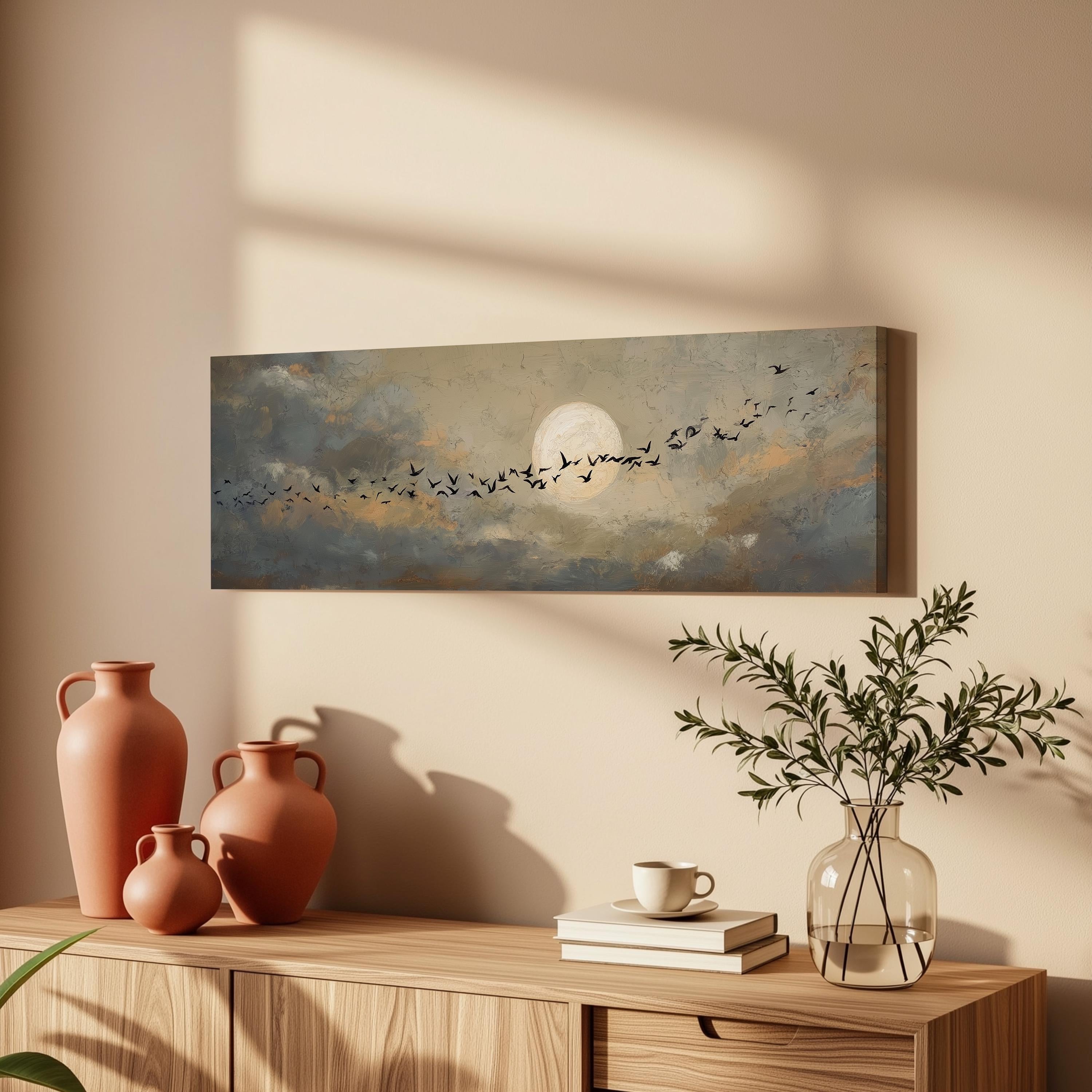 a wooden cabinet with a painting of a flock of birds flying across a cloudy sky above it, along with three orange vases and a glass vase with greenery.