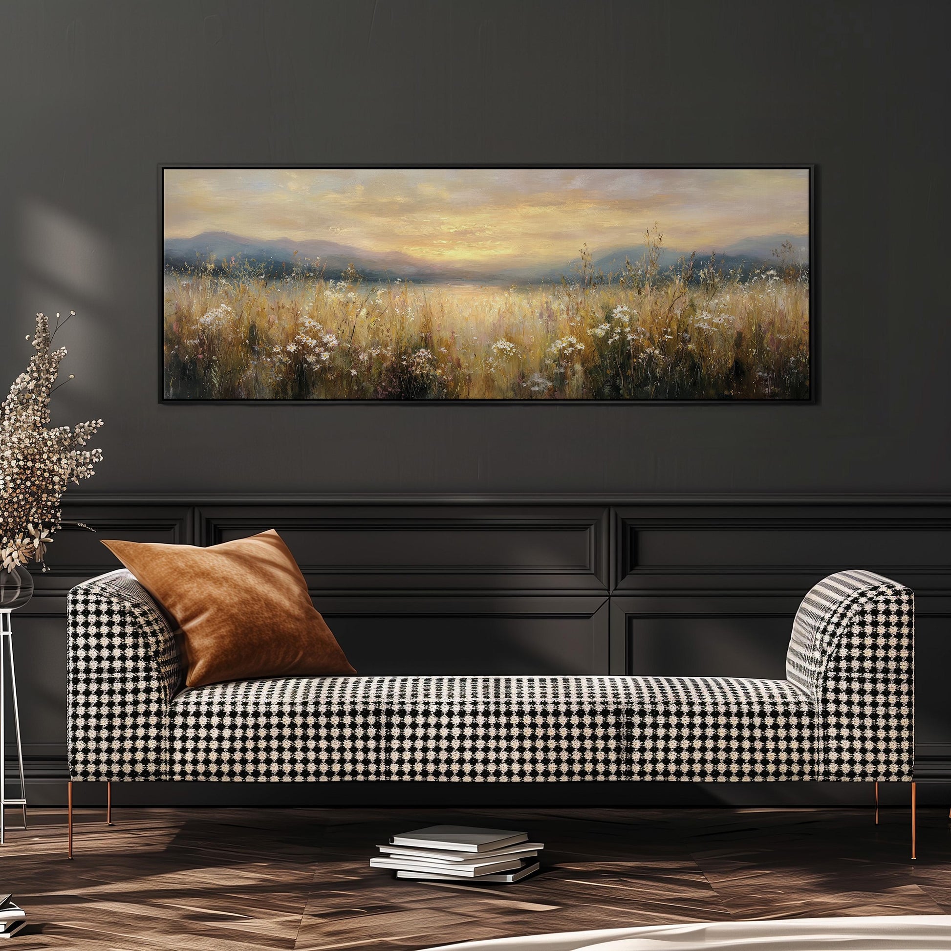 a large painting of a field with a sunset in the background, hanging on a wall above a black and white checkered sofa with a brown throw pillow.