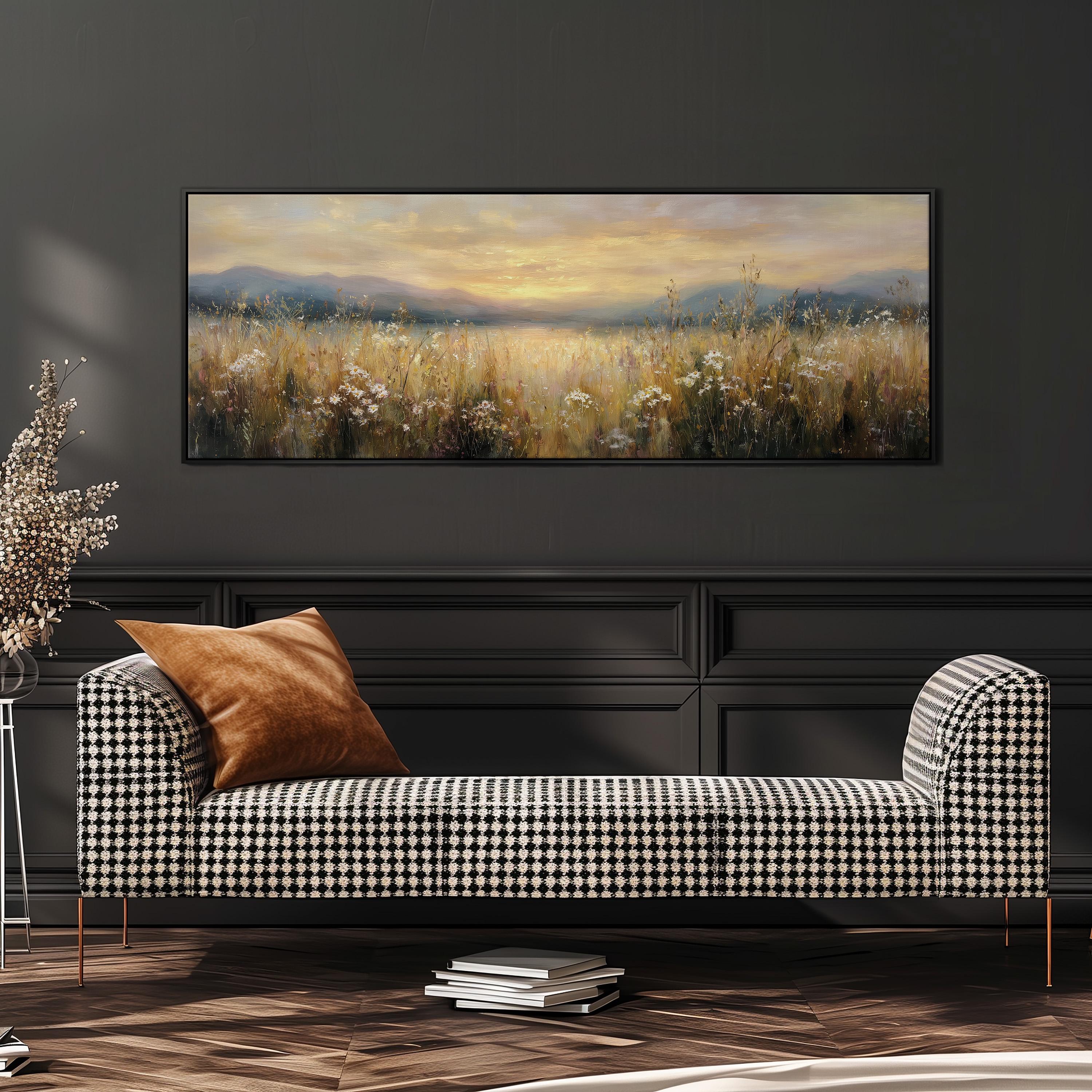 a large painting of a field with a sunset in the background, hanging on a wall above a black and white checkered sofa with a brown throw pillow.