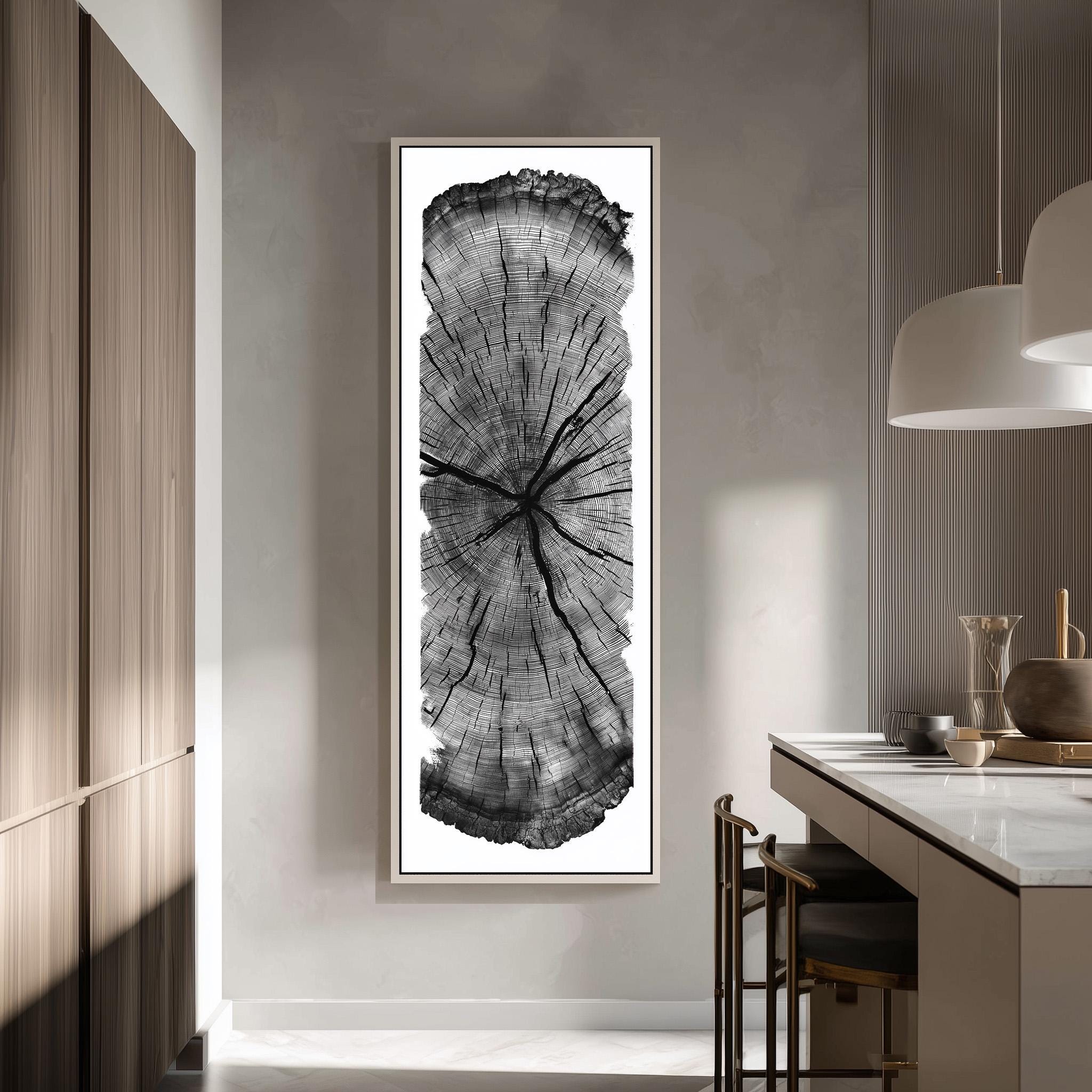 a large, framed black and white photograph of a tree trunk, which is mounted on the wall in a modern kitchen setting.