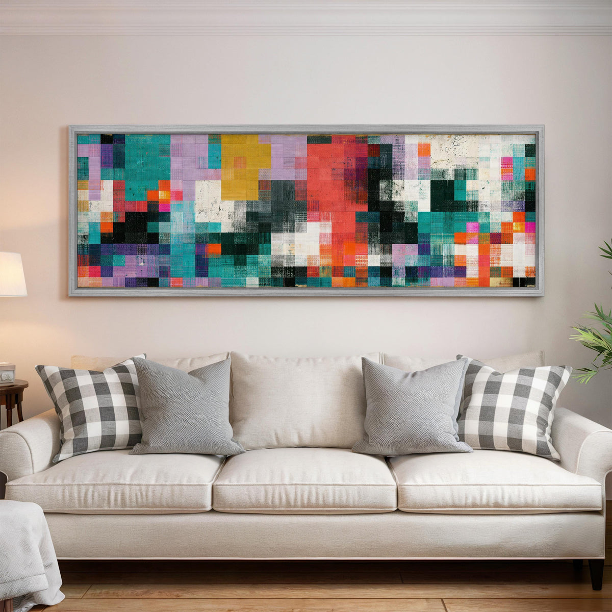 Teal and coral patchwork color blocks panoramic canvas print above a white sofa in a bright living room