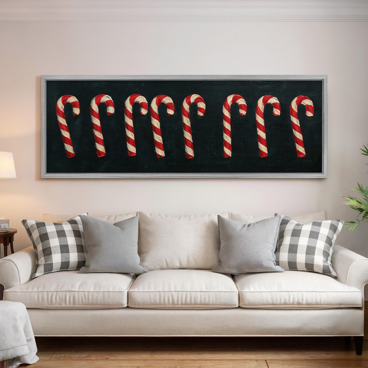 Row of candy canes on black panoramic canvas print above a white sofa in a bright living room