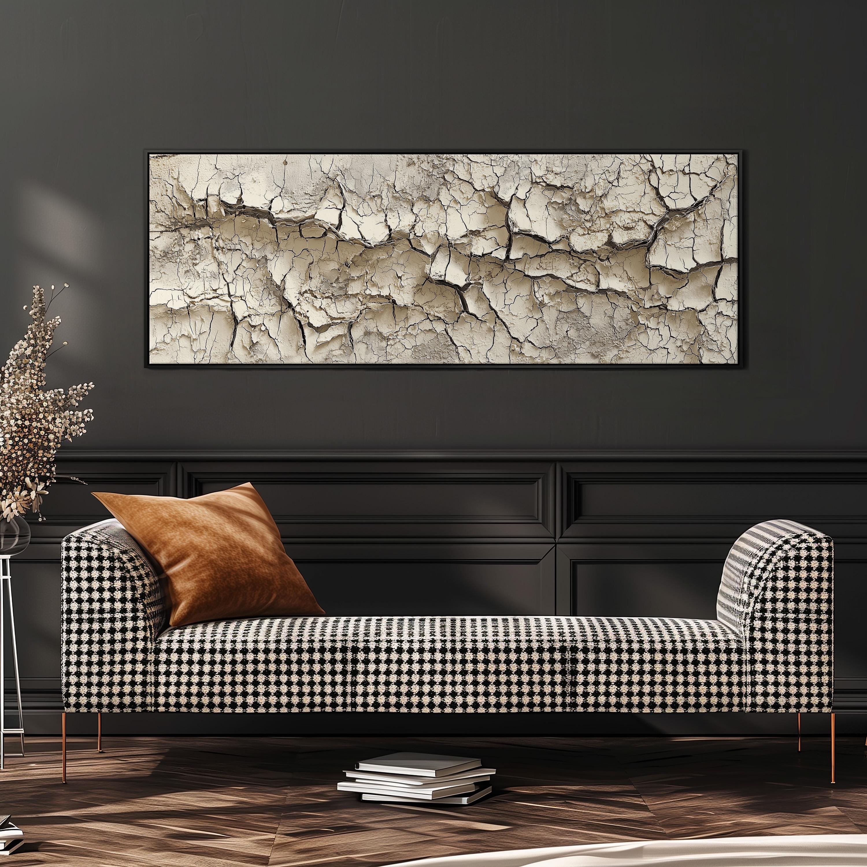 a black and white checkered sofa with a brown throw pillow, set against a dark wall with a large framed artwork hanging above it.