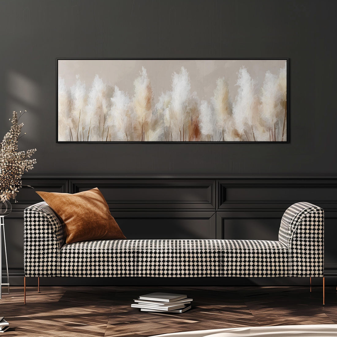 a large, framed painting of tall, white flowers hanging on a wall above a brown sofa with orange cushions.