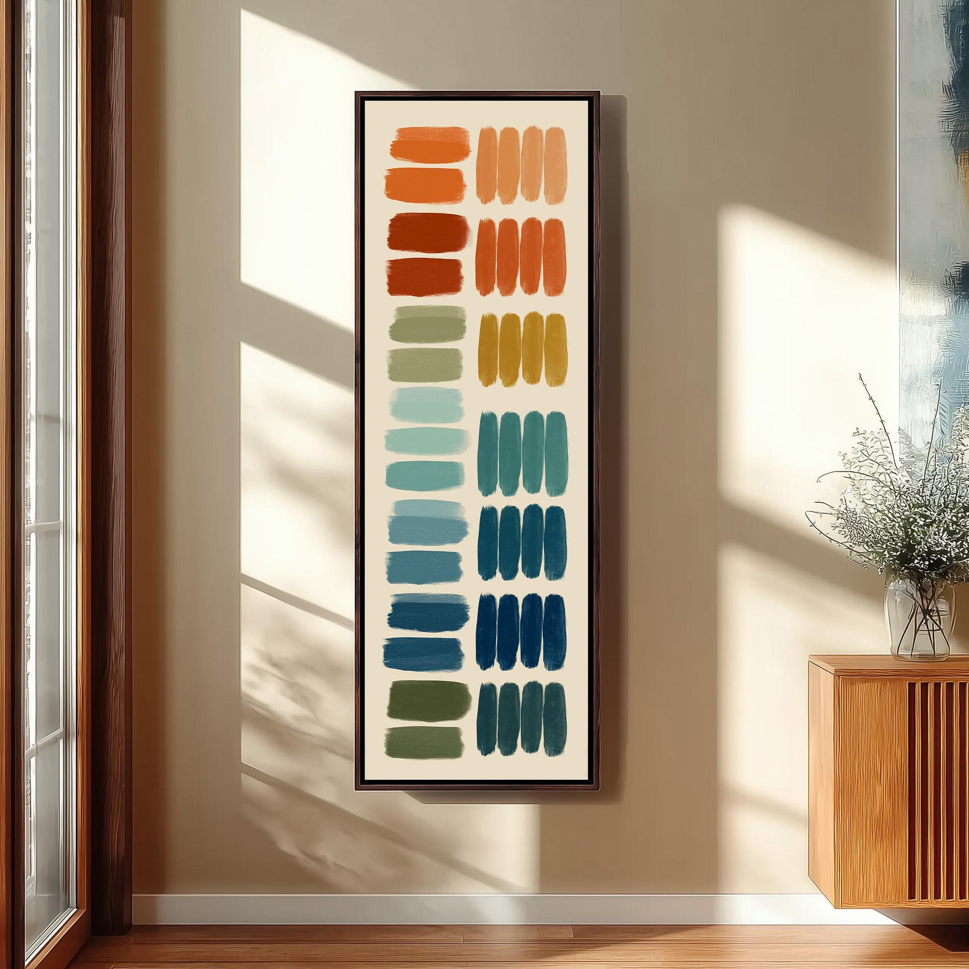 a large abstract painting hanging on a wall, with a wooden cabinet and a vase of flowers to the right of the painting.
