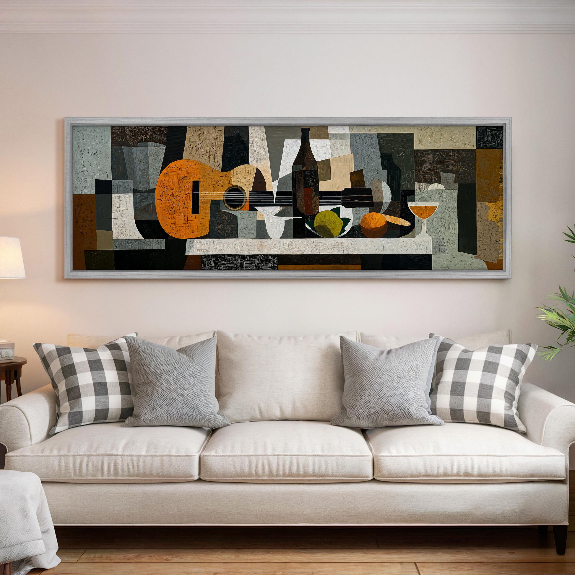 a large abstract painting hanging on a wall above a white couch with gray and white plaid throw pillows.