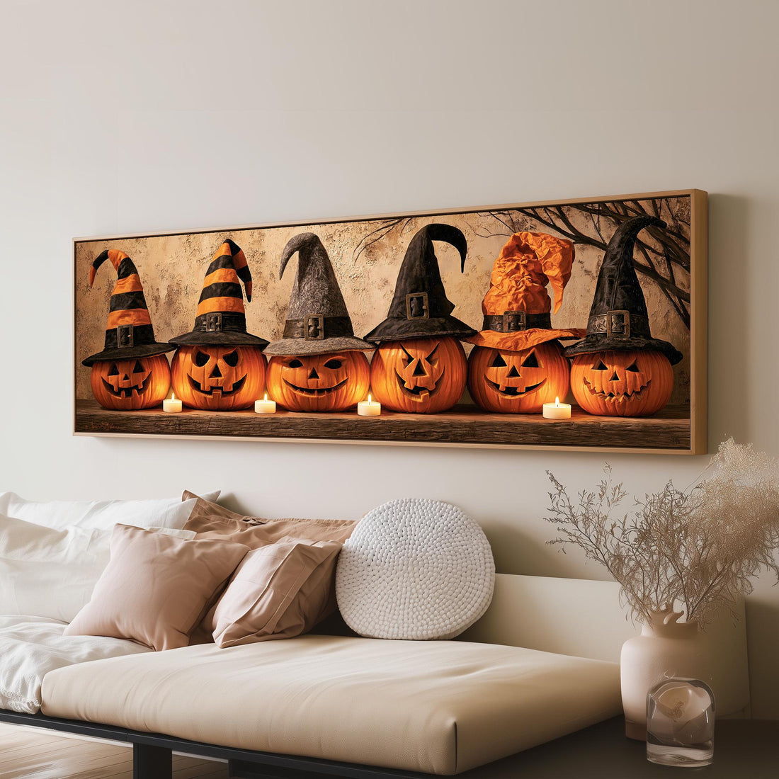 Jack-o'-lanterns wearing witch hats by candlelight long horizontal canvas print above a sofa in a living room
