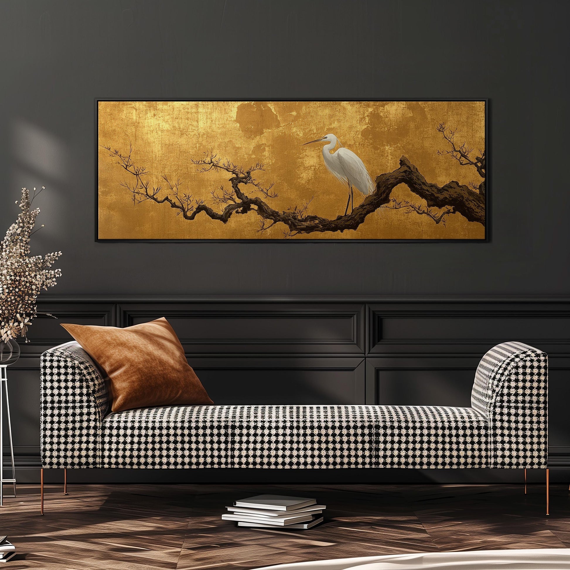 a large, ornate black and white checkered sofa with a brown throw pillow, set against a dark wall with a gold-colored painting of a white egret perched on a branch above it.