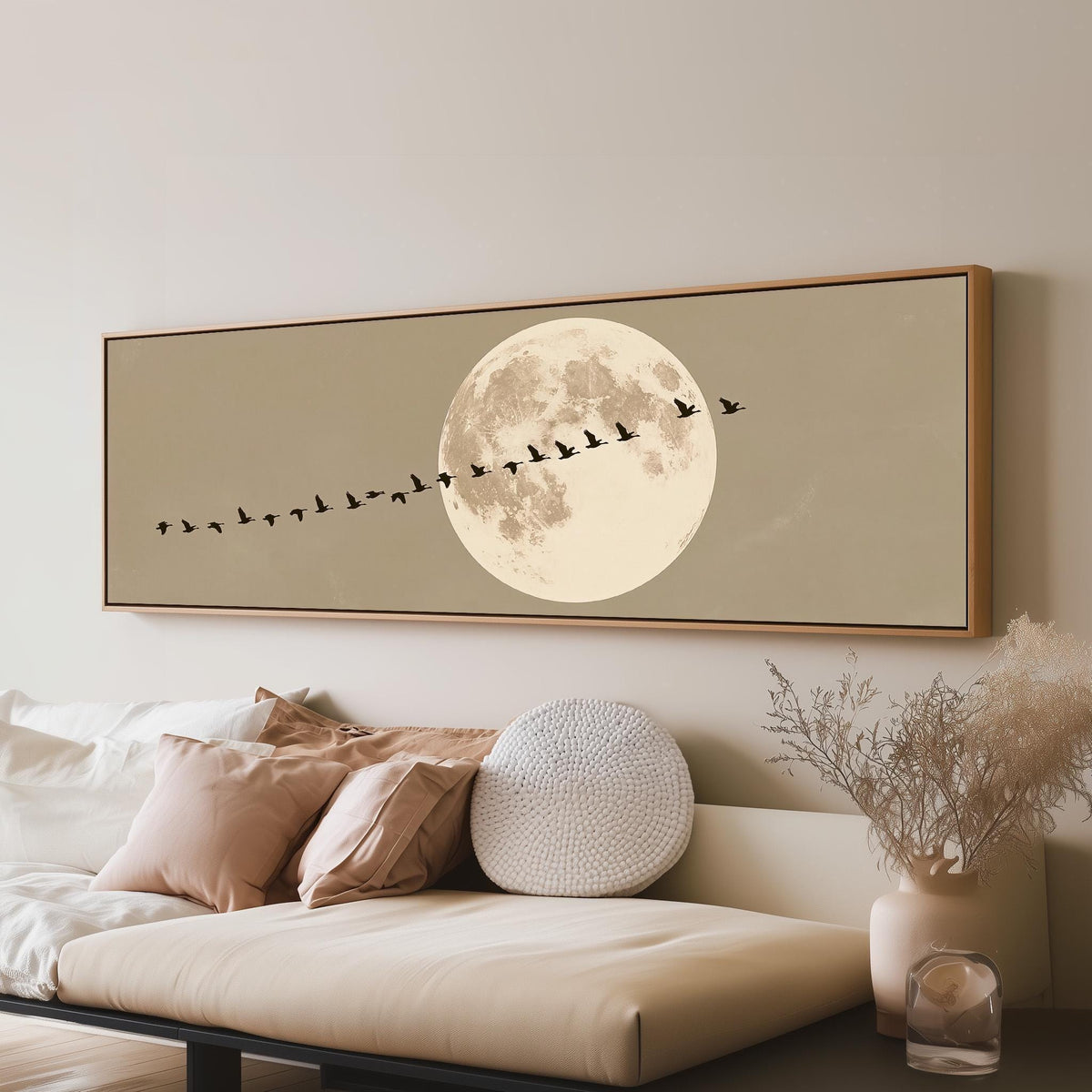 Geese flying past a full moon long horizontal canvas print above a sofa in a living room