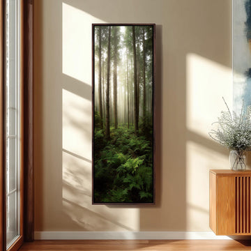 a large framed picture of a forest scene hanging on a wall, with sunlight streaming through the trees and casting shadows on the floor.