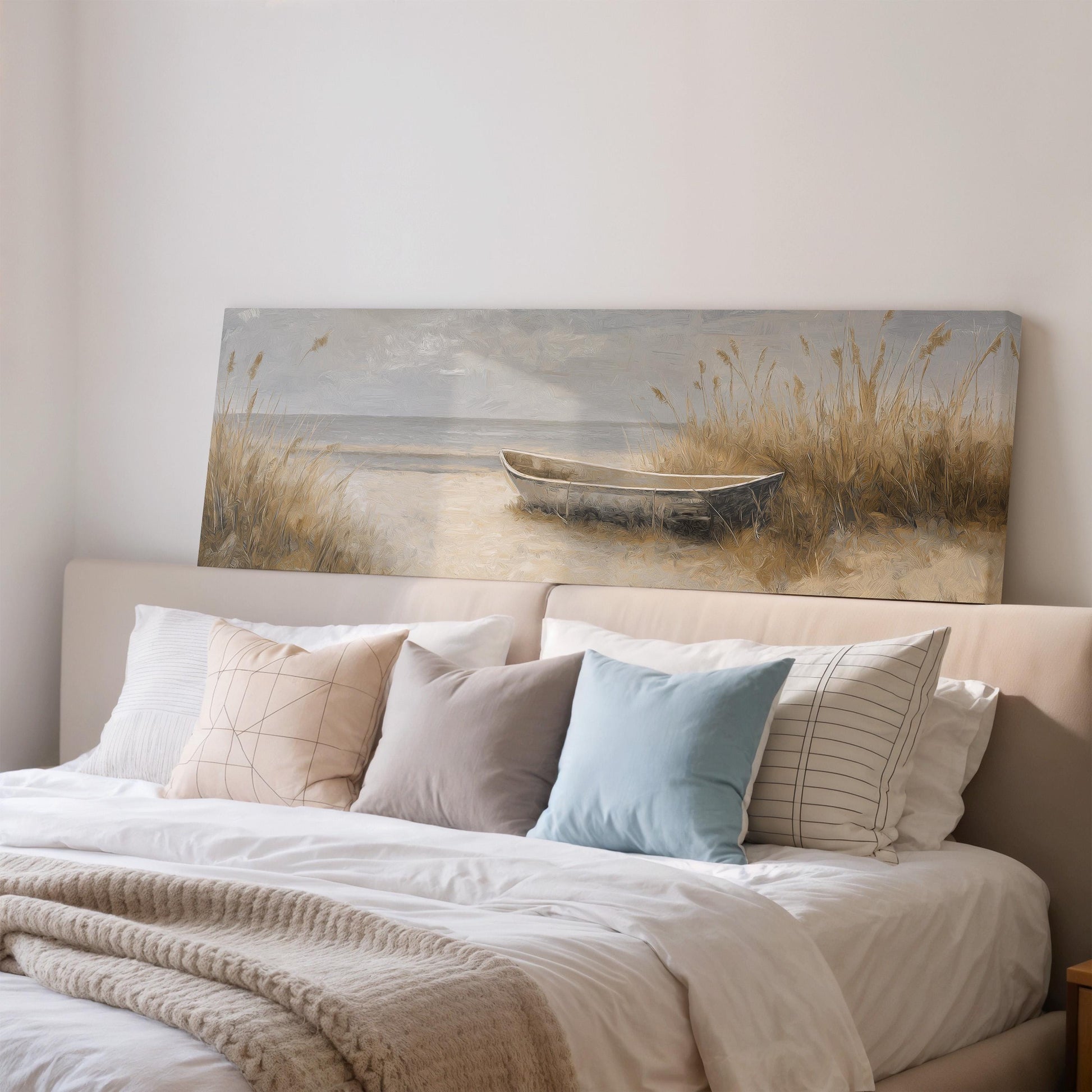 a large painting of a boat on a beach, hanging above a bed with white bedding and pillows.
