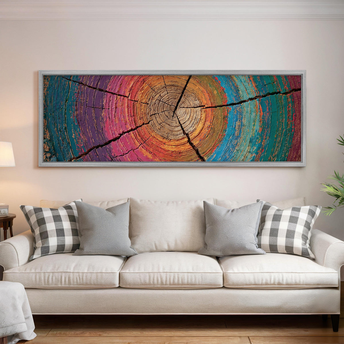 Rainbow tree ring panoramic canvas print above a white sofa in a bright living room