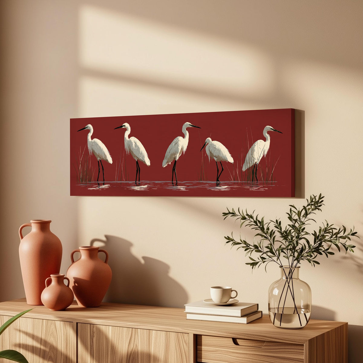 White egrets wading on crimson red long horizontal canvas print above a wooden sideboard