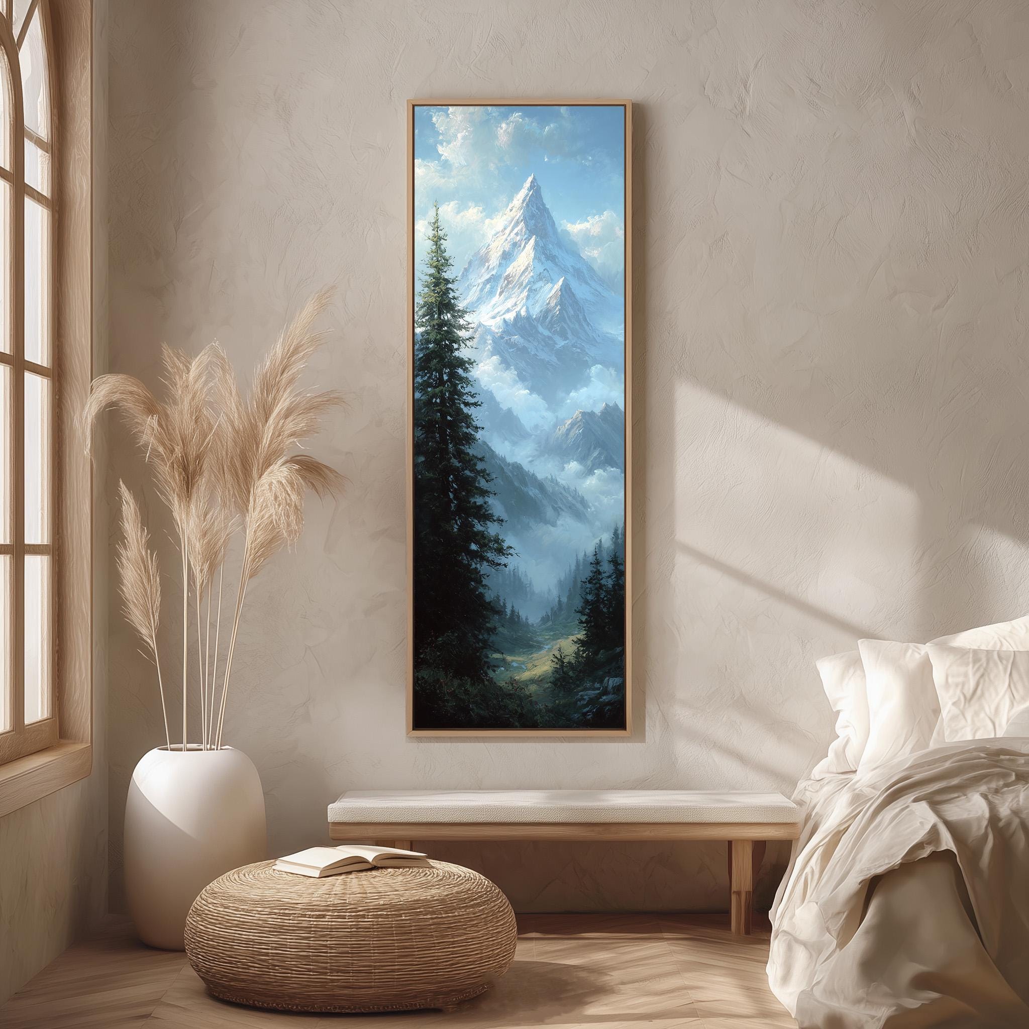 a serene bedroom scene with a large painting of a mountain landscape hanging on the wall. The painting depicts a majestic mountain peak surrounded by lush green trees and a clear blue sky. The room is decorated with a white bed, a wooden bench, and a woven ottoman. The overall atmosphere of the room is calm and peaceful, with the painting serving as a focal point in the space.