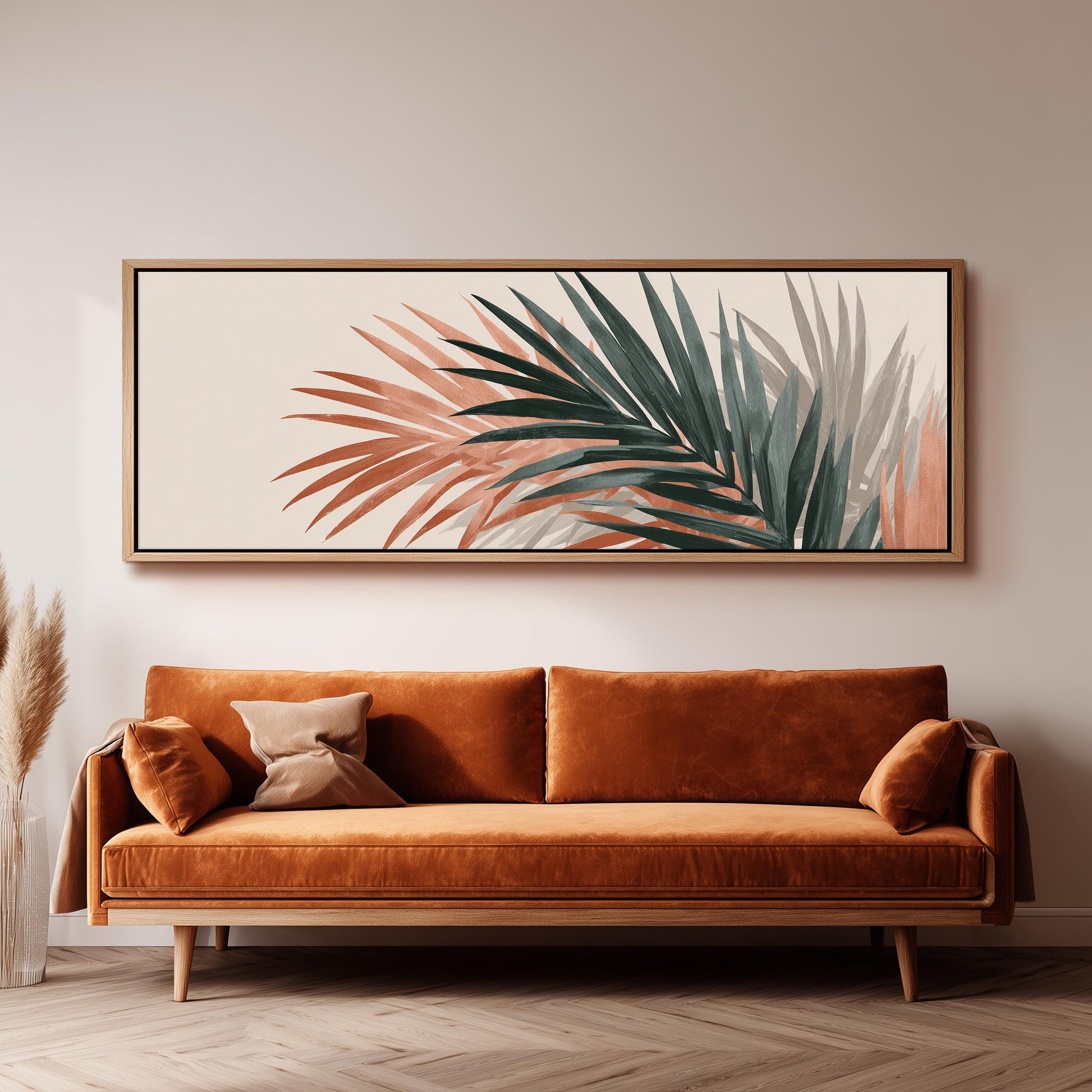 a large, framed painting of palm leaves hanging on a wall above a brown sofa with orange cushions.