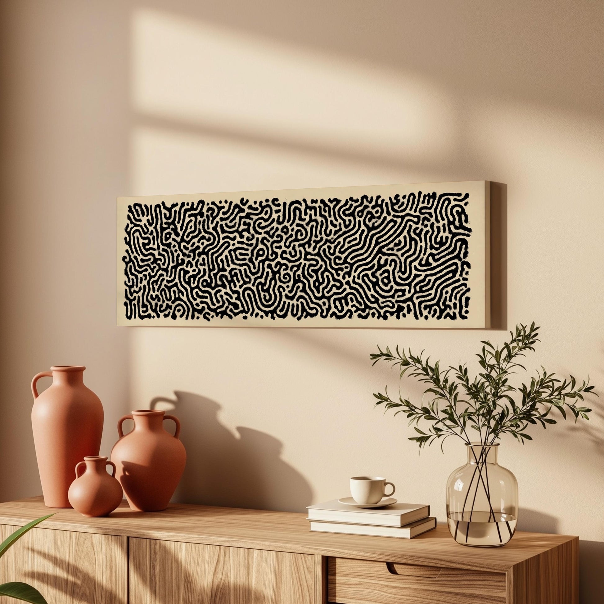 a wooden cabinet with a vase, a plant, and a framed abstract artwork on the wall above it.