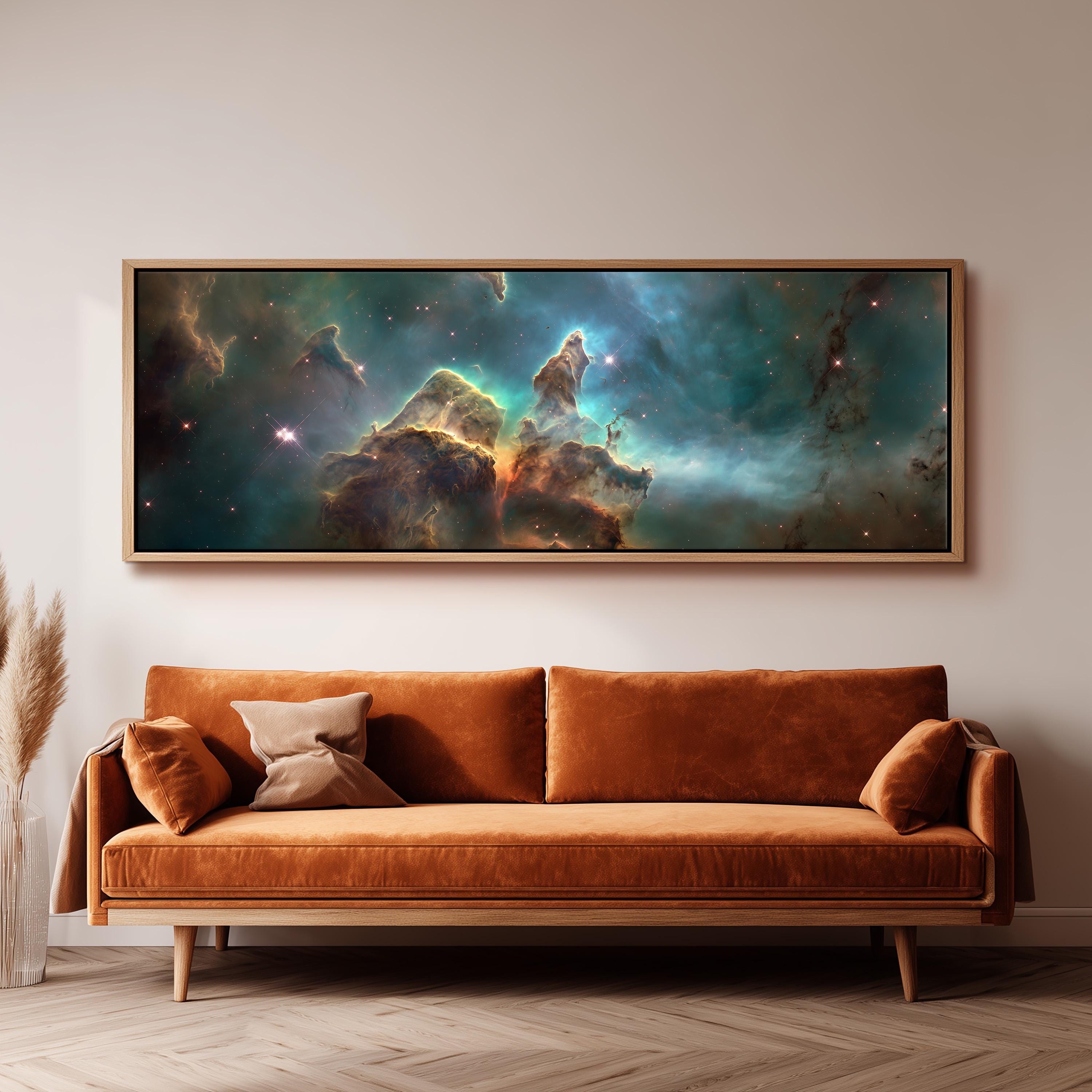 a large, framed painting of a nebula hanging on a wall above a brown sofa.
