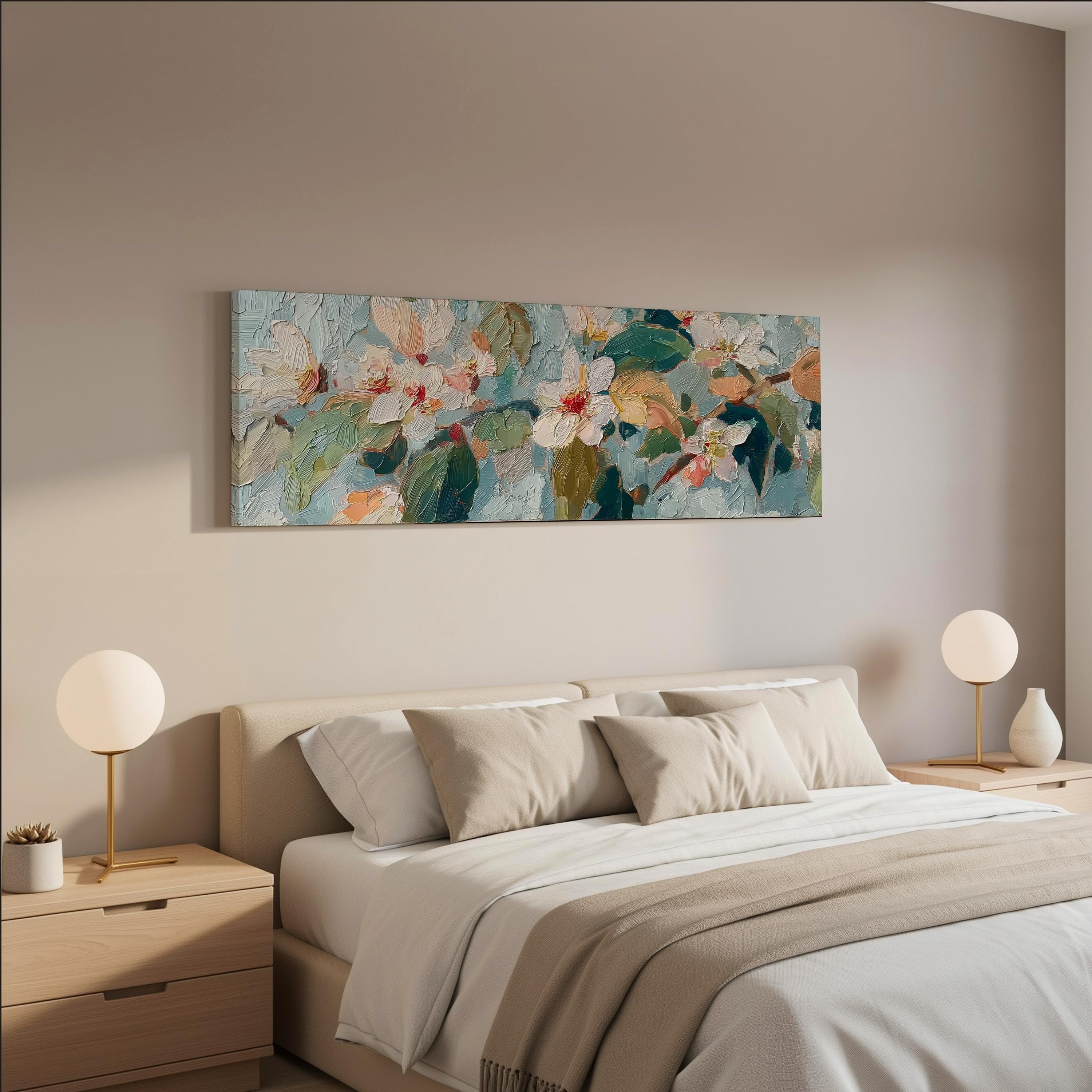 a serene and modern bedroom with a large bed adorned with white and beige bedding, flanked by two white lamps on nightstands. Above the bed hangs a large painting of flowers in a blue and green color palette, creating a harmonious and visually appealing atmosphere.