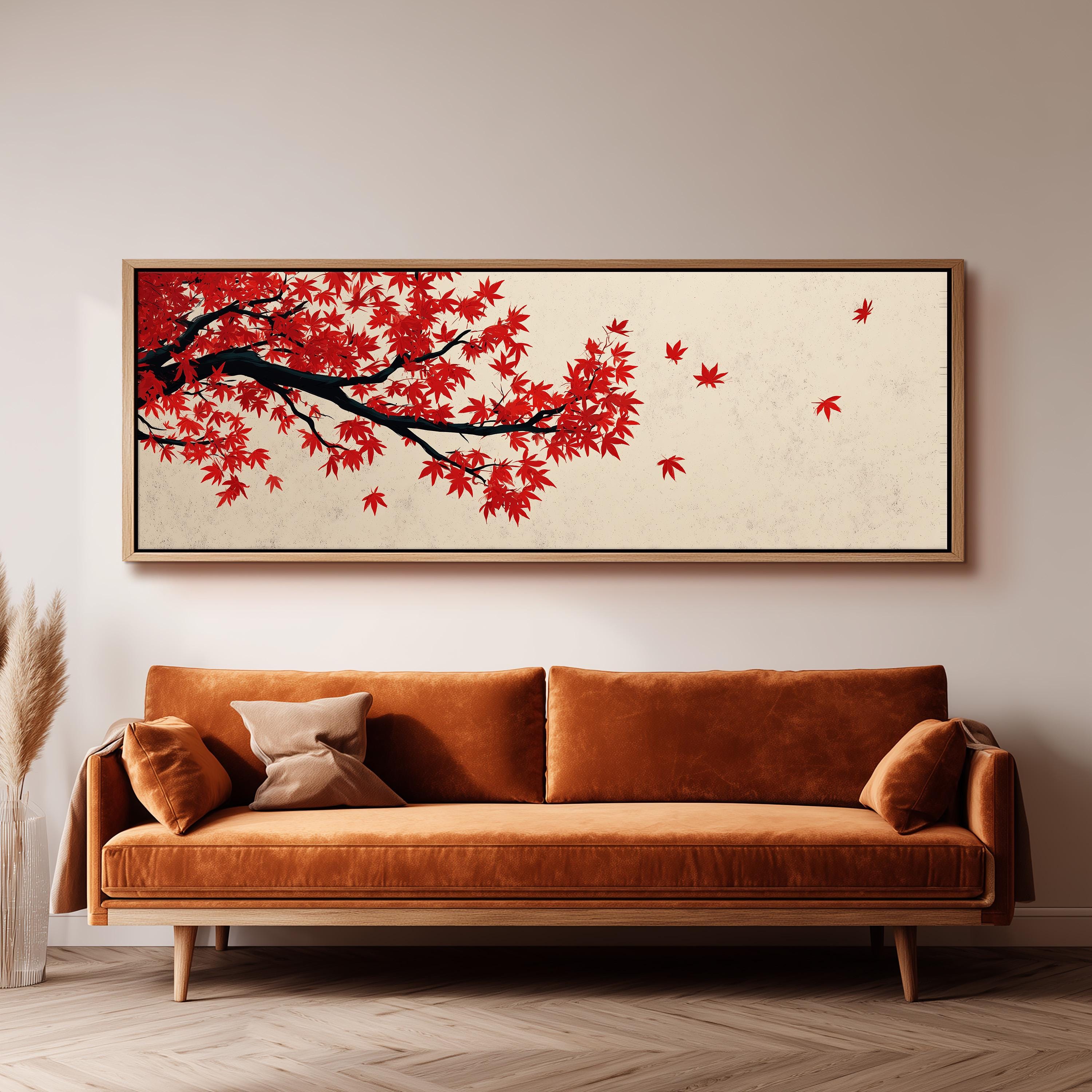 a large, framed painting of a tree with red leaves hanging on a wall above a brown sofa.