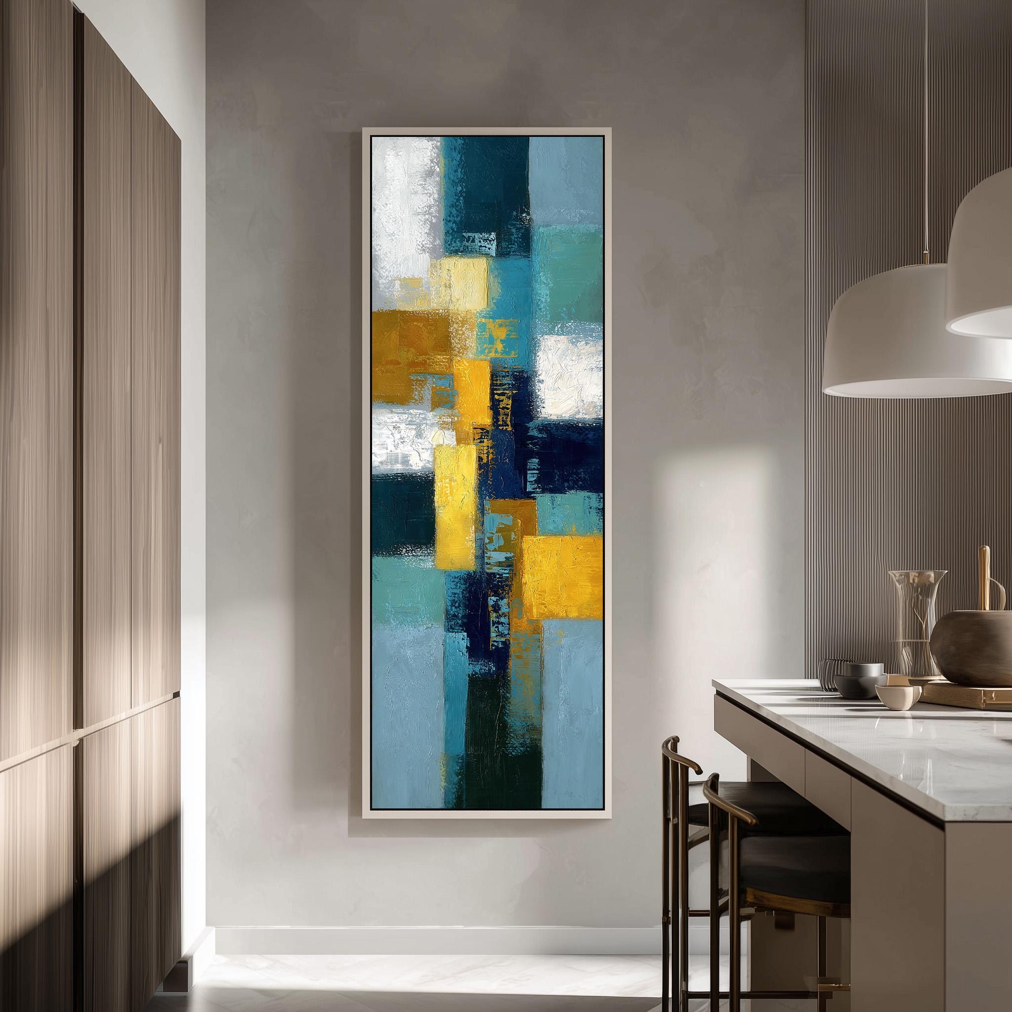 a modern kitchen with a large abstract painting hanging on the wall. The painting has a vibrant mix of blue, yellow, and green colors, creating a lively and energetic atmosphere. The kitchen is well-equipped with a counter, chairs, and a dining table, providing a comfortable space for meal preparation and dining.