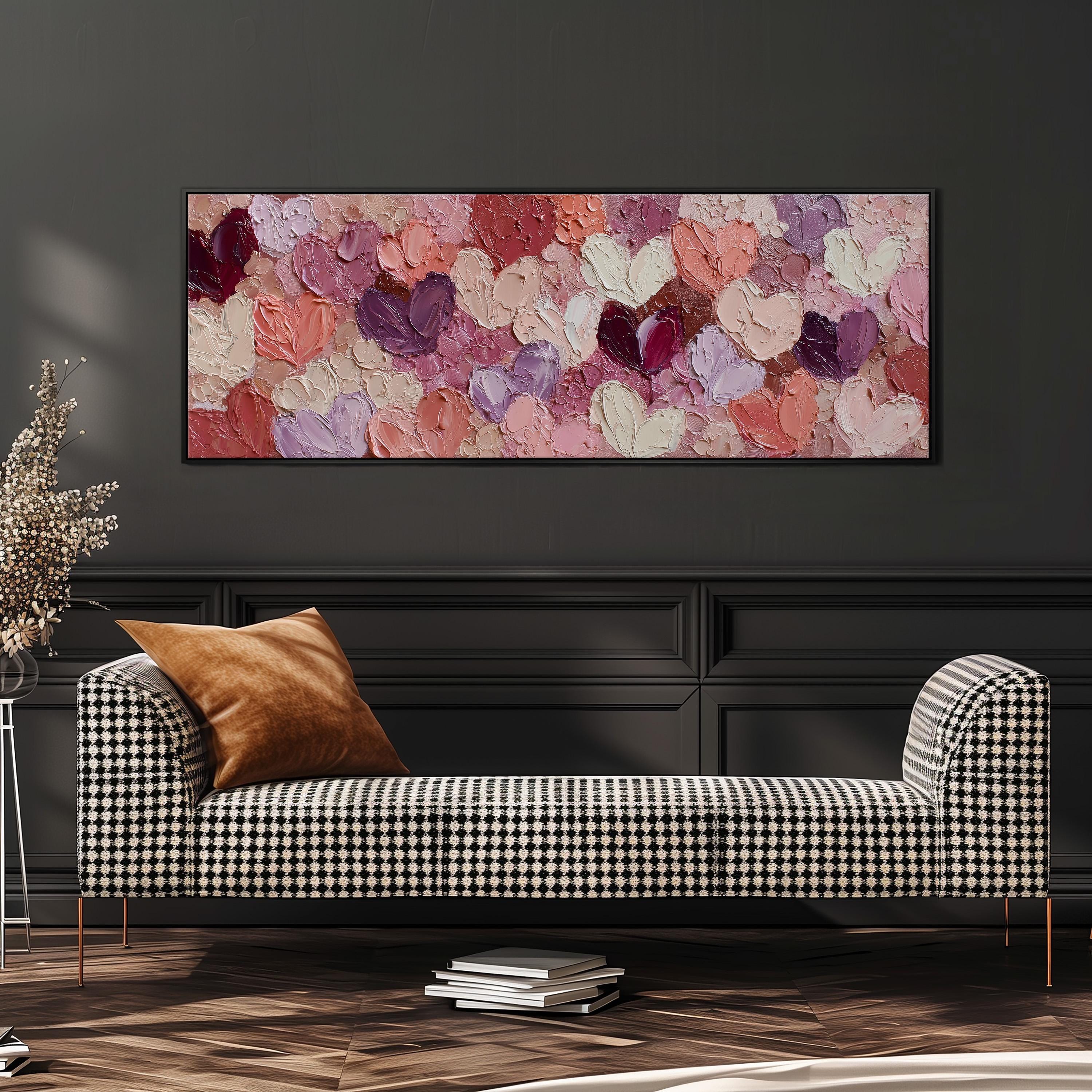 a black and white checkered sofa with a brown throw pillow, set against a dark wall with a large framed painting of pink and purple hearts hanging above it.